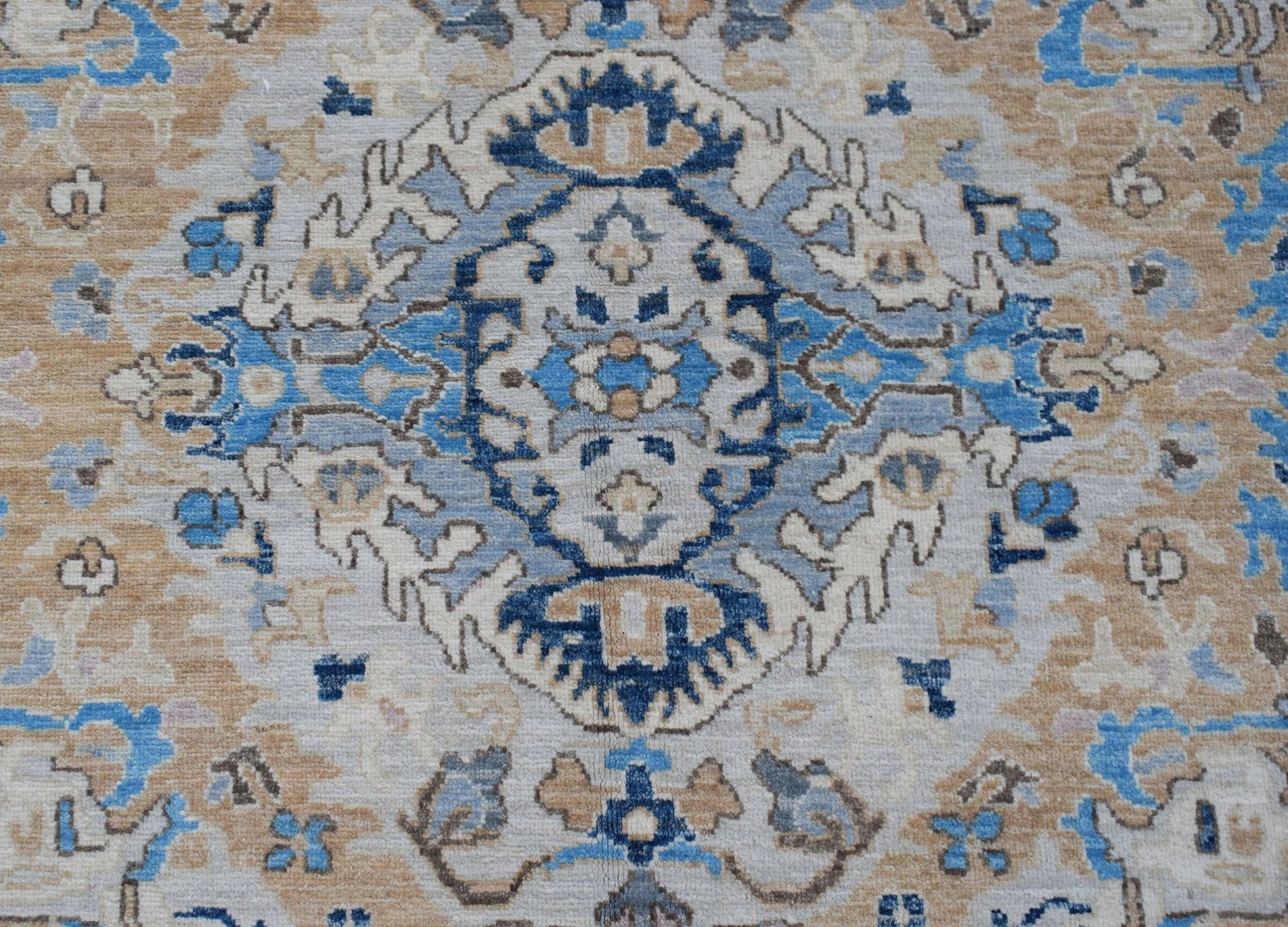 A handwoven Afghan Chobi rug featuring a traditional blue and beige floral medallion pattern.