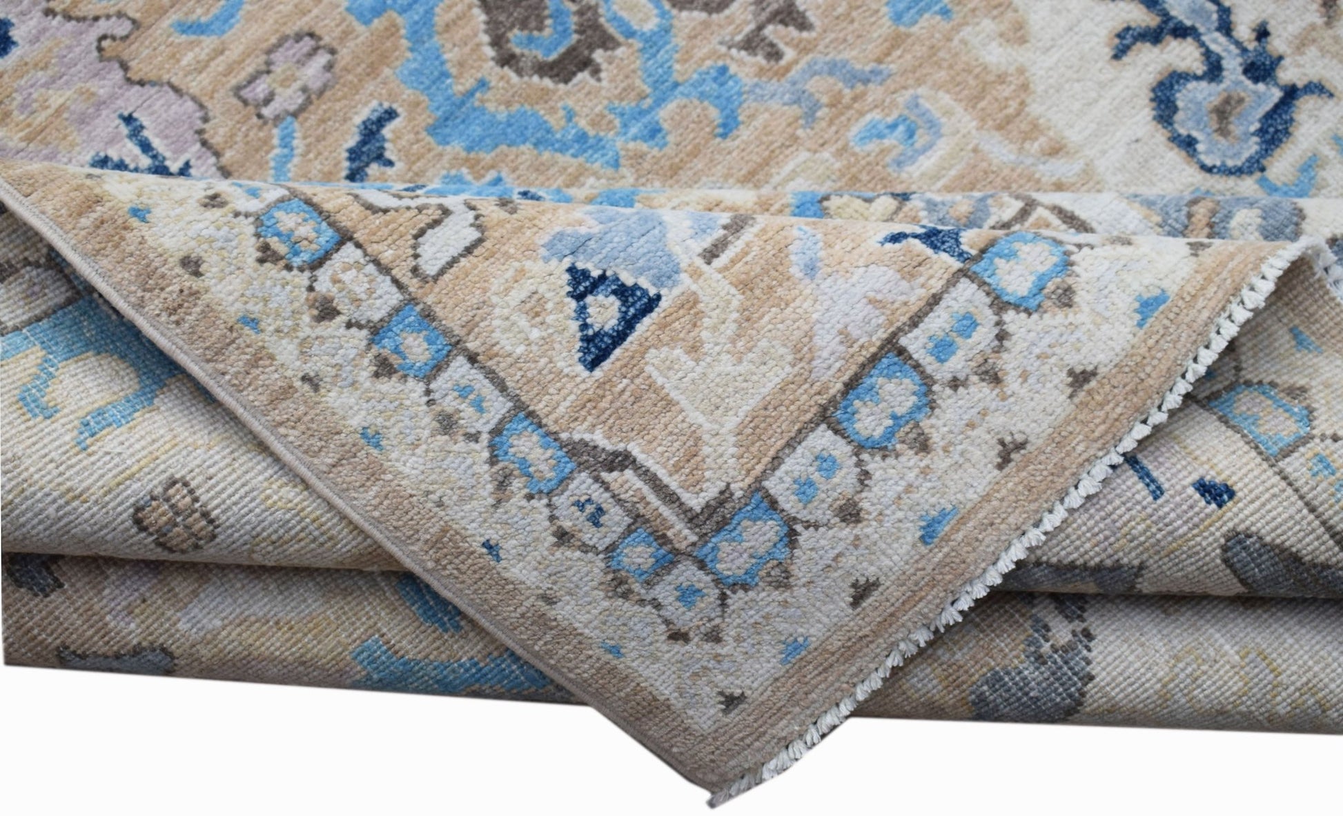 A folded Afghan Chobi rug featuring a traditional floral pattern in shades of blue and beige.