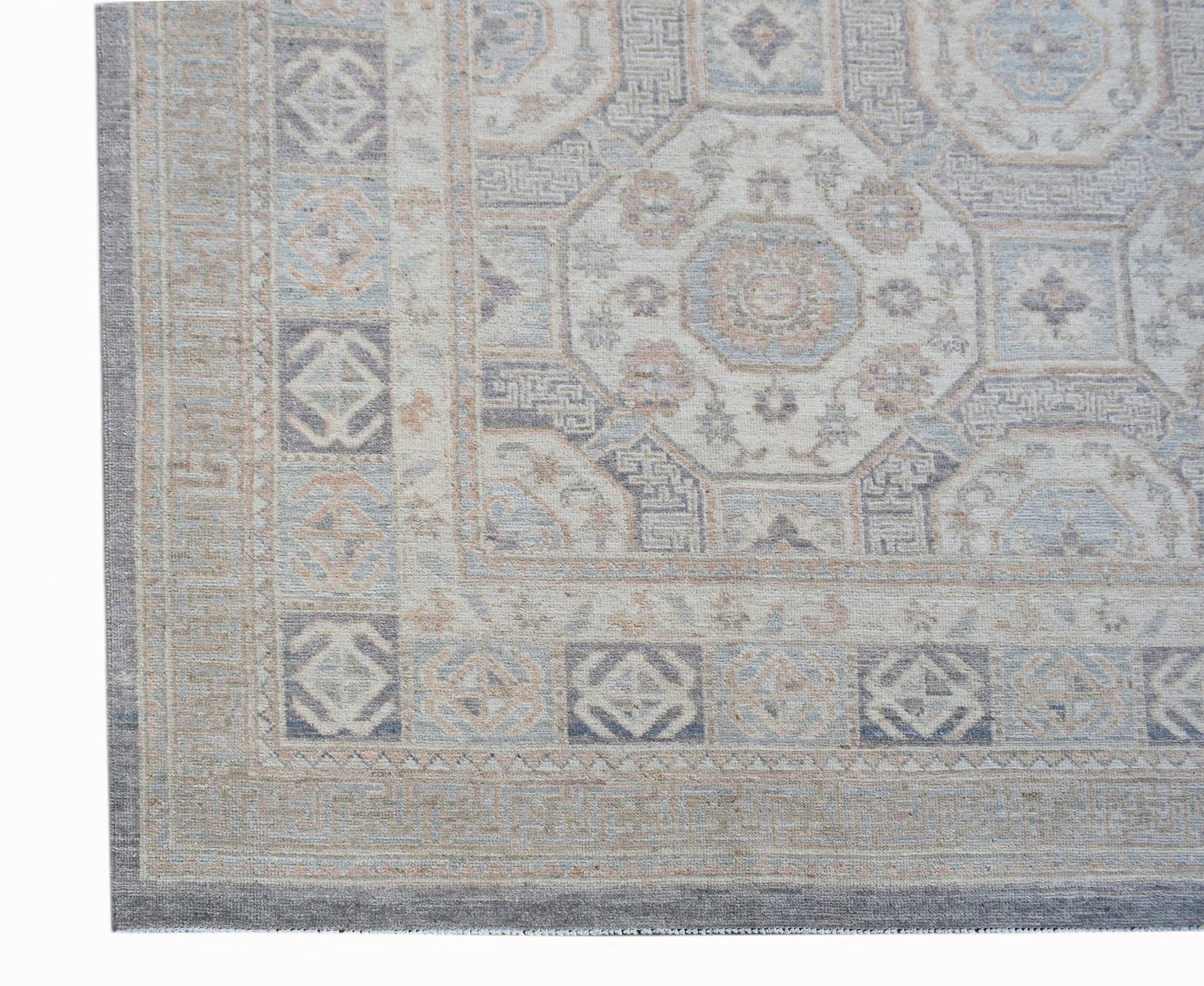 A handmade Afghan Chobi rug featuring a traditional geometric pattern in soft, muted earth tones.