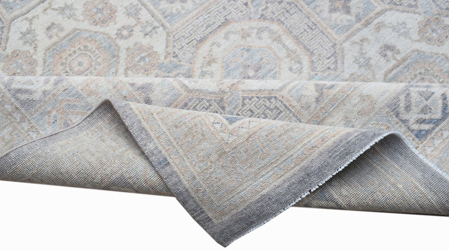 A handwoven Afghan Chobi rug featuring a traditional geometric pattern in soft neutral tones.