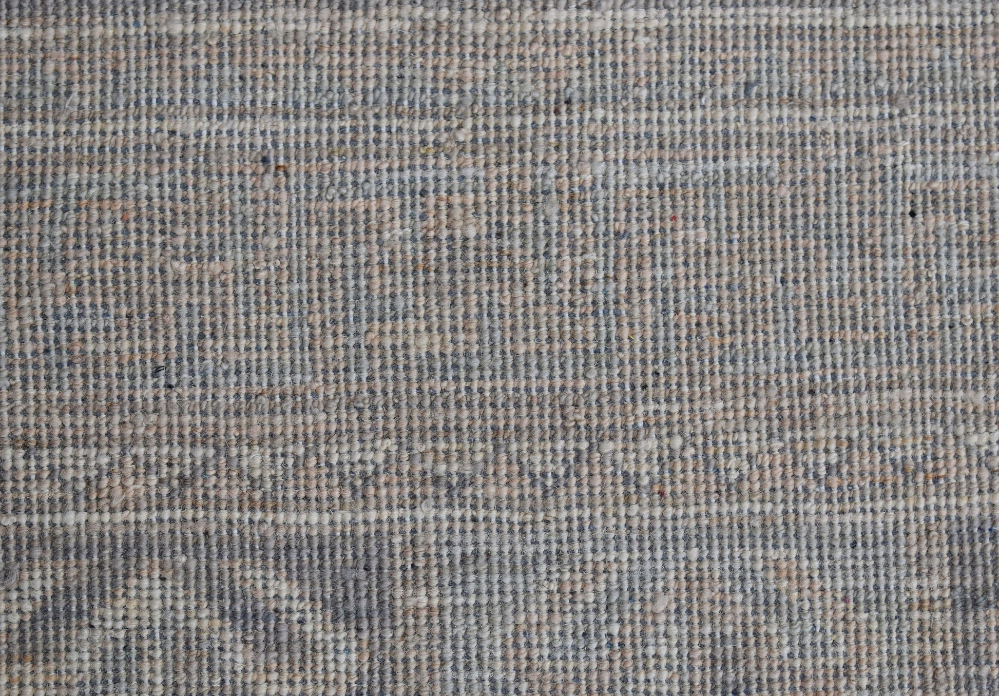 A close-up view of a handwoven Afghan Chobi rug featuring a textured, neutral-toned wool weave.