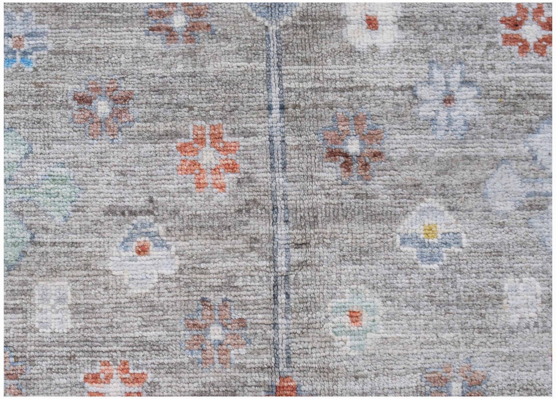 Handwoven Afghan Chobi rug featuring a grey field with small, colorful floral motifs.