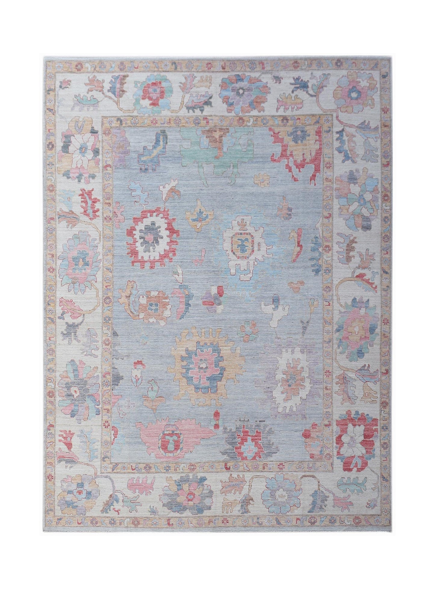 A handmade transitional Oushak rug featuring a light blue field with colorful floral motifs.