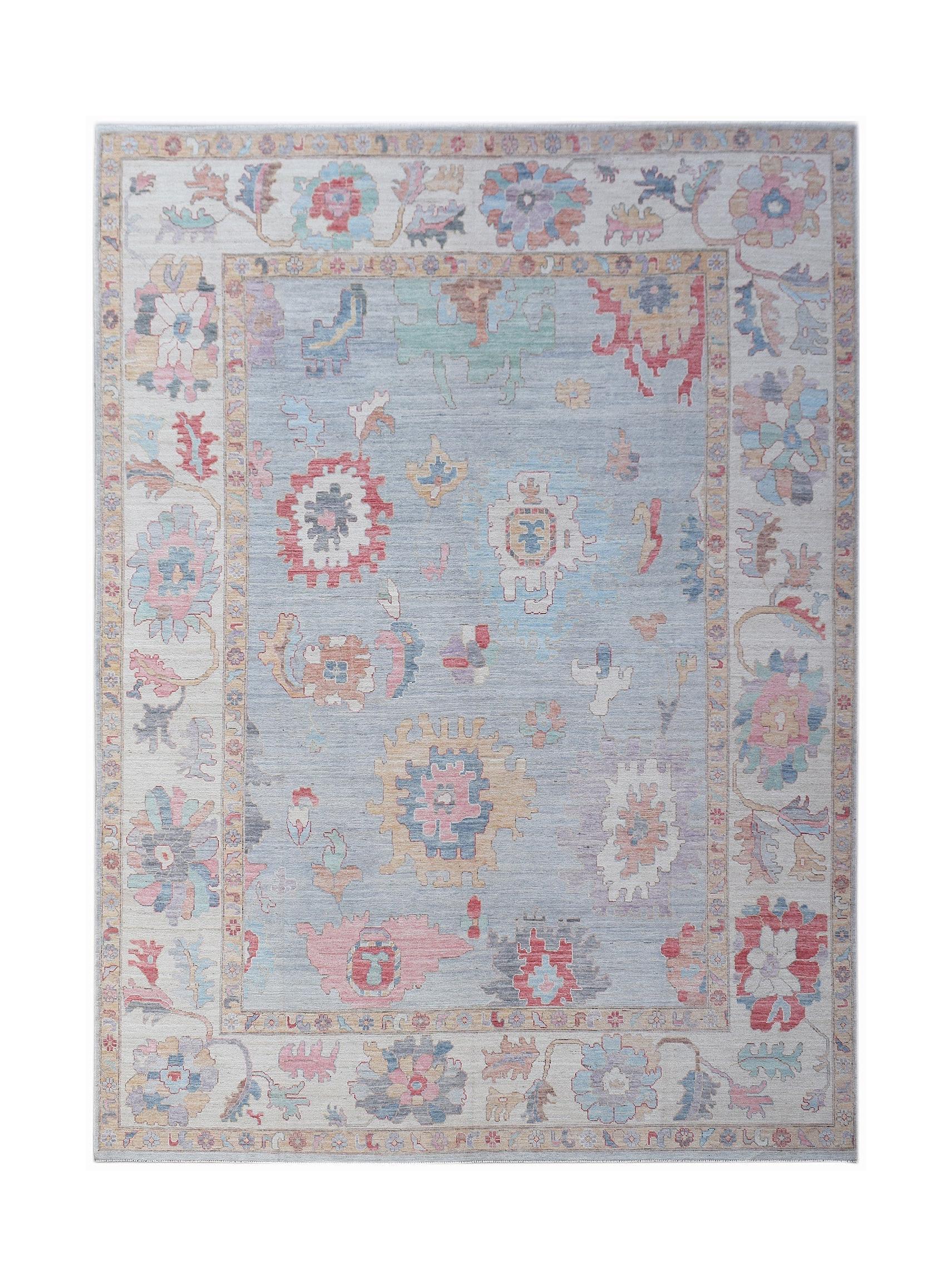 A handmade transitional Oushak rug featuring a light blue field with colorful floral motifs.