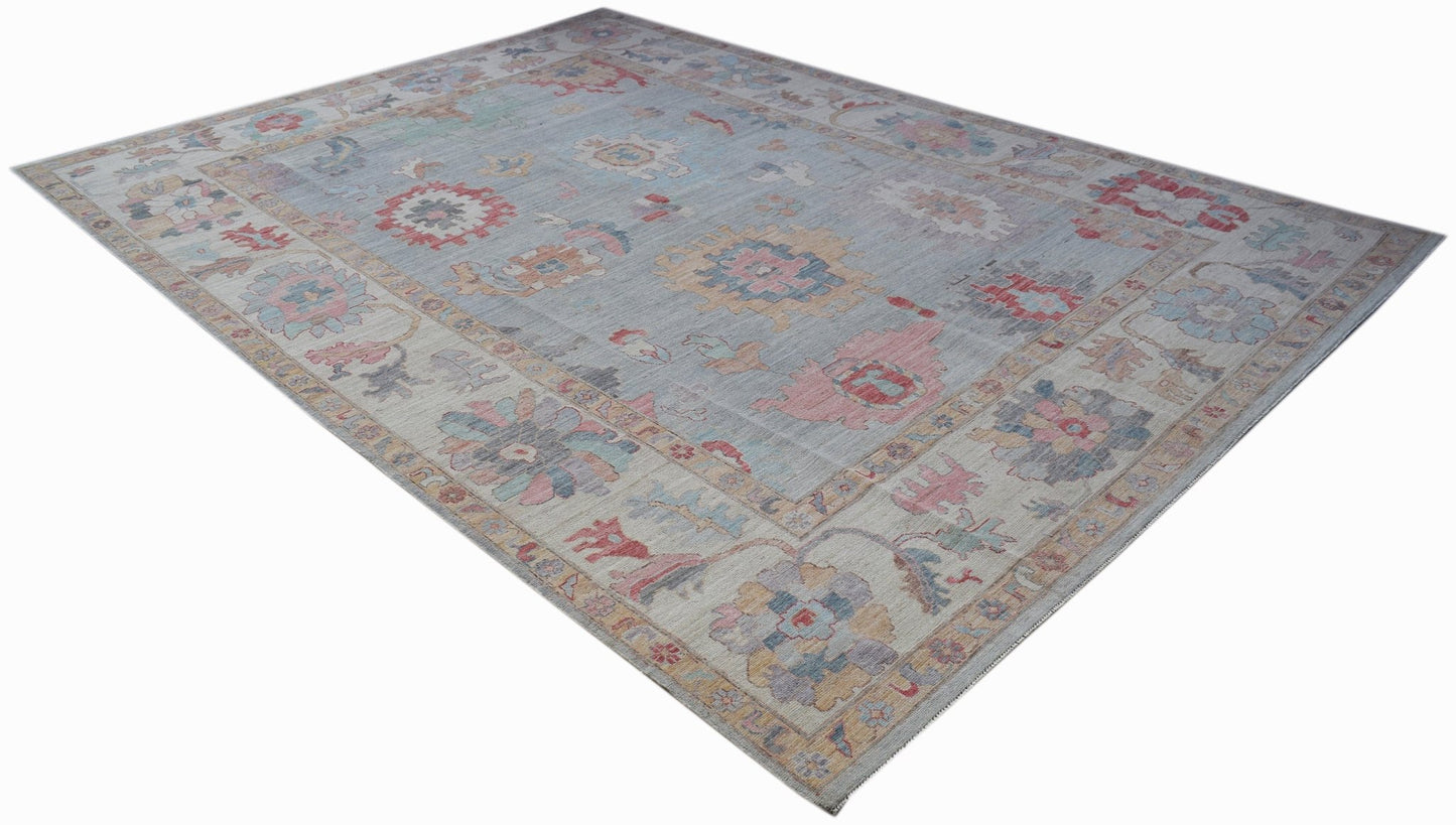 A rectangular transitional Oushak rug featuring a light blue field with floral motifs.