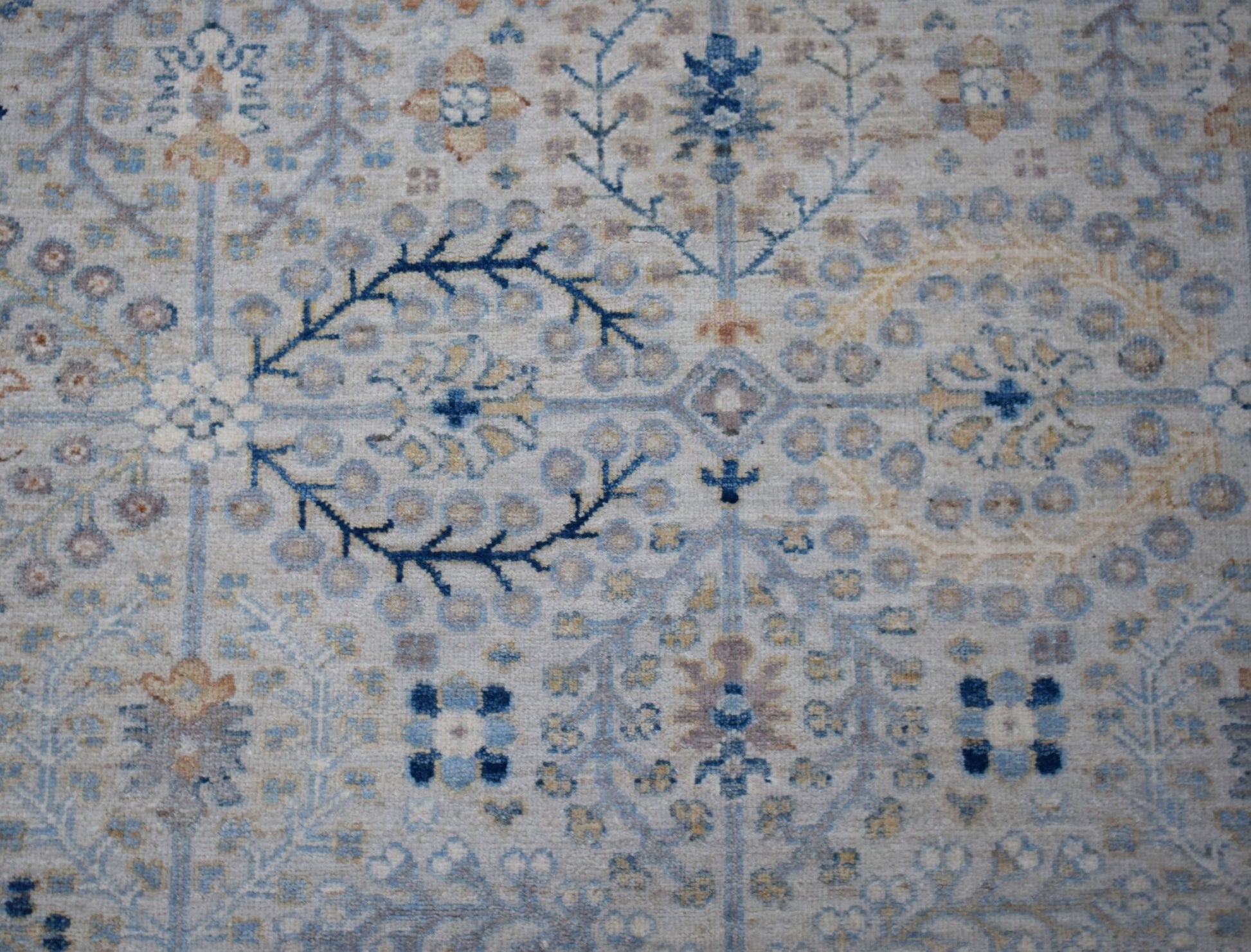 A handwoven Afghan Balkh rug featuring a traditional floral pattern in soft blue and beige tones.