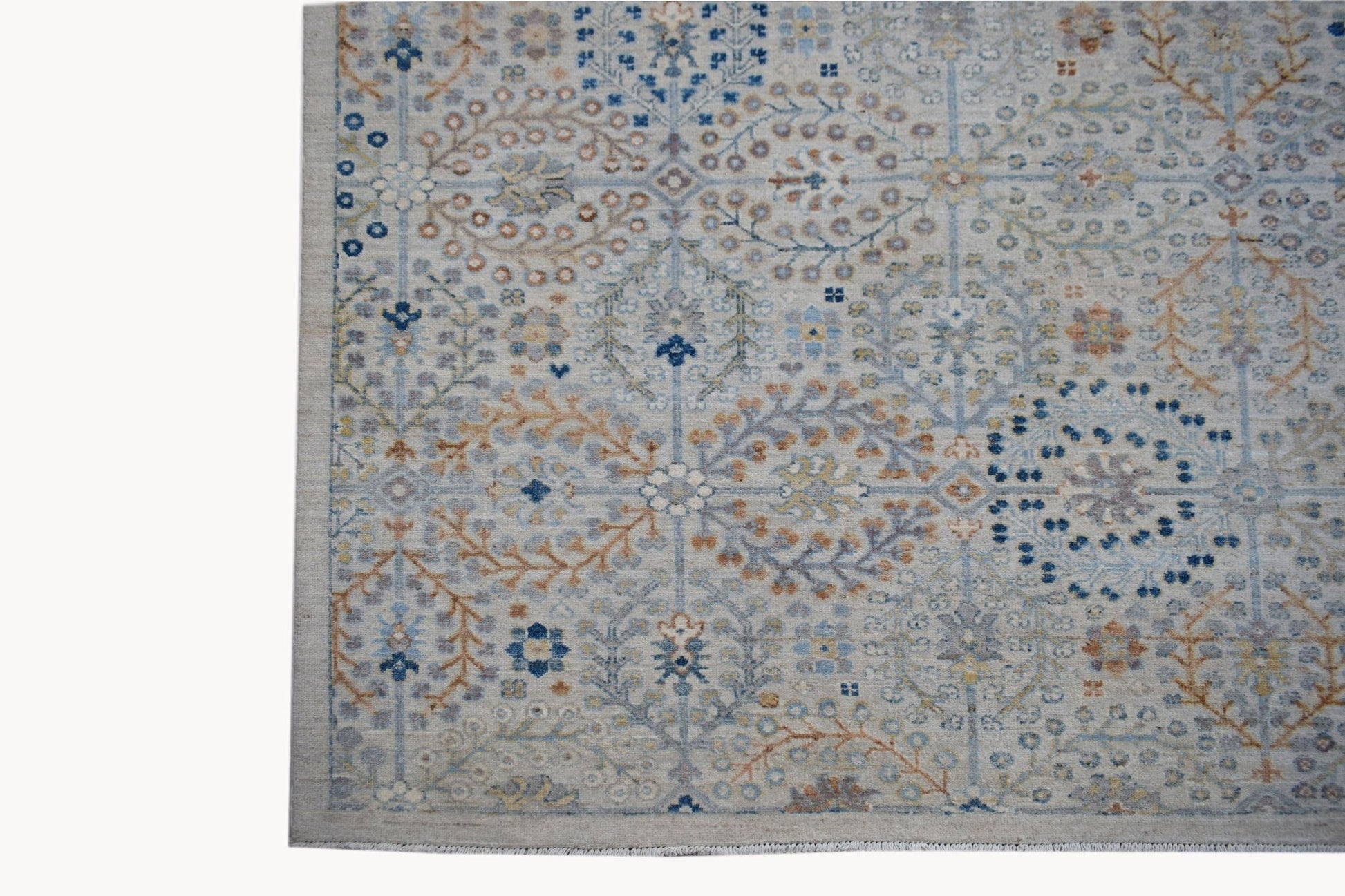An Afghan Balkh rug featuring a traditional floral pattern in soft blue and earthy tones.