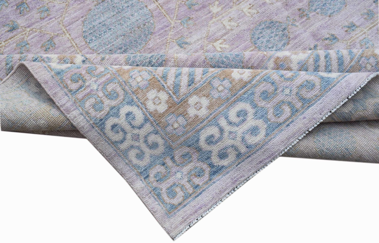 A handwoven Afghan Chobi rug featuring a traditional Khotan pattern in shades of lavender and blue.