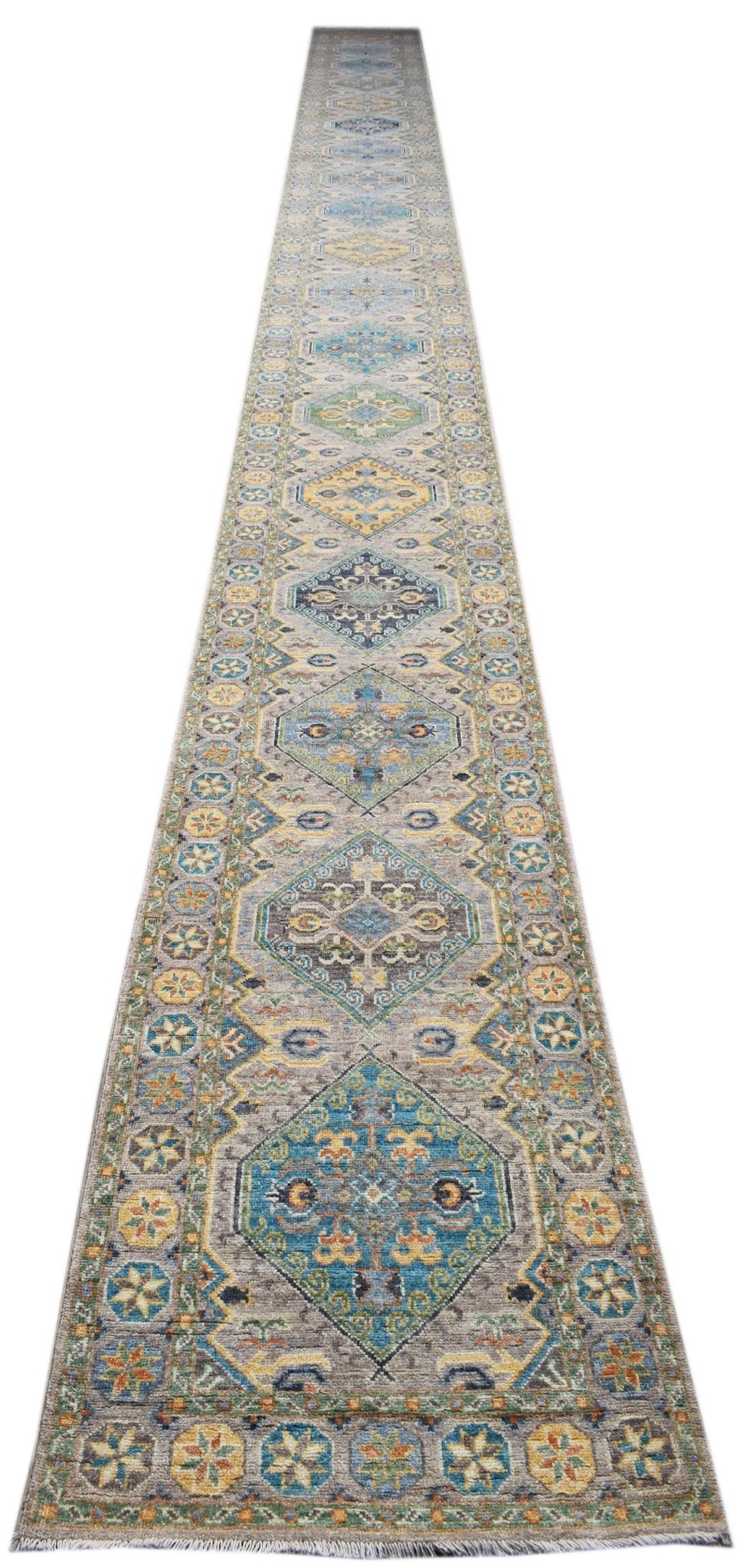 A long, handmade Afghan Chobi runner rug featuring a repeating diamond pattern in blue and gold.