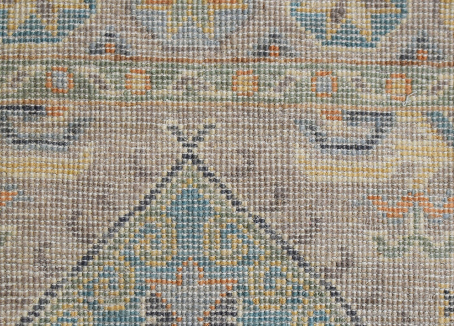 A close-up of an Afghan Chobi runner featuring a traditional geometric pattern in muted earth tones.