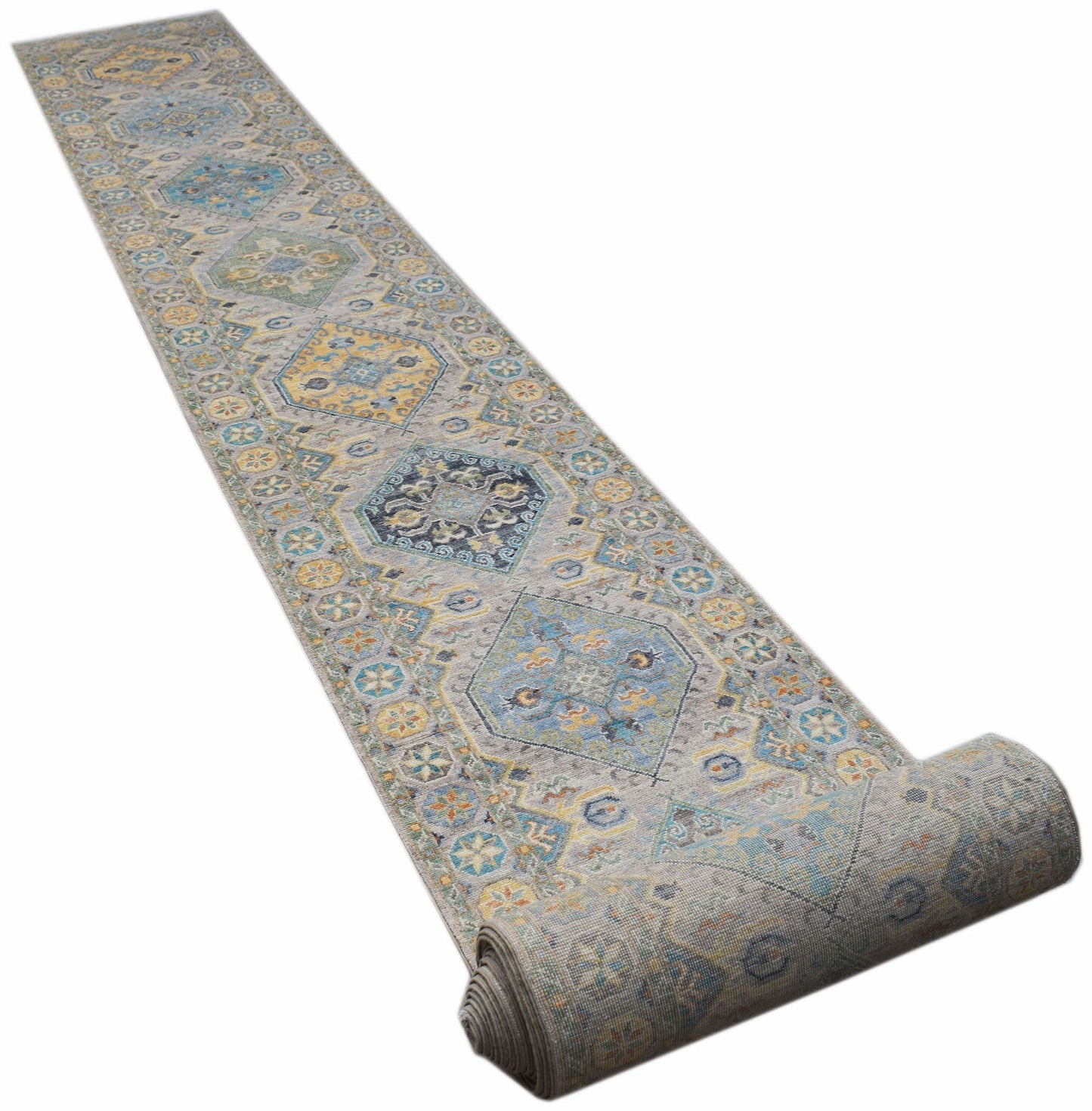 A long, handwoven Afghan Chobi runner rug featuring traditional geometric patterns in blue and gold.