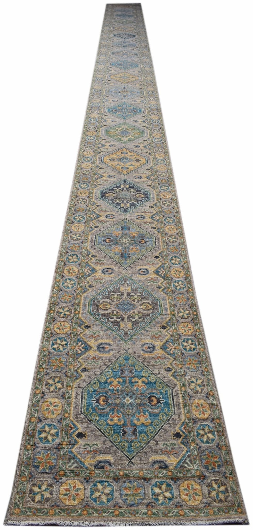 A long, handwoven Afghan Chobi runner rug featuring geometric diamond patterns in earthy tones.
