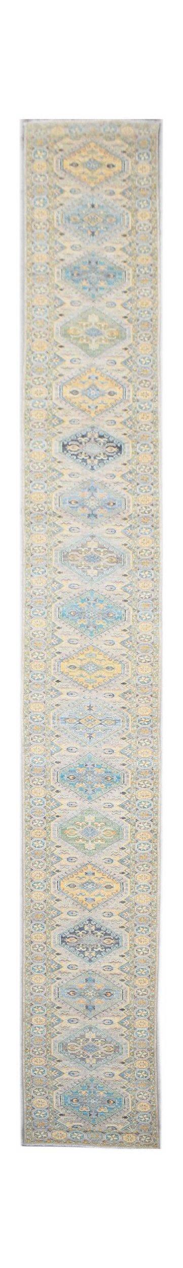 A long, handwoven Afghan Chobi runner rug featuring a repeating diamond pattern in soft blue and gold.