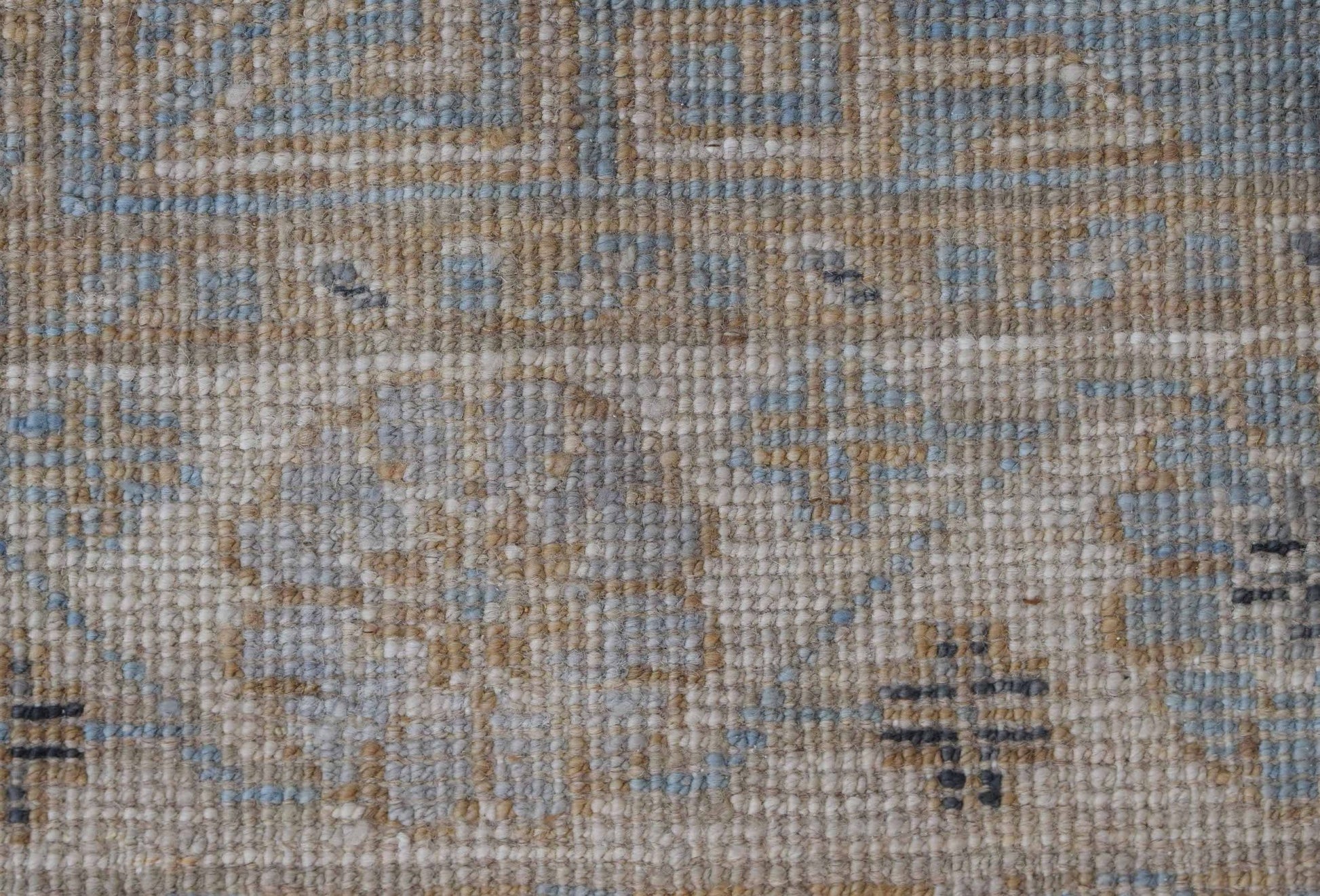 A close-up of a handwoven Afghan Chobi runner featuring a textured wool pattern in blue and tan.