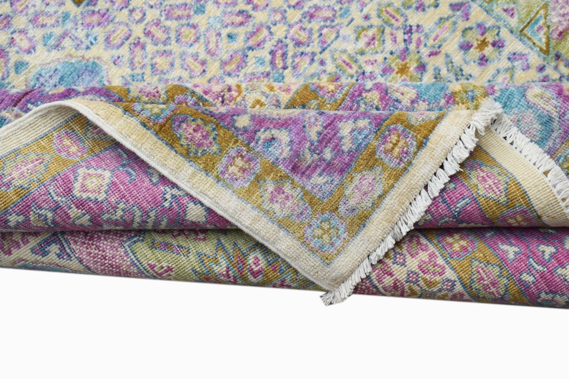 A folded Afghan Balkh rug featuring a traditional floral pattern in shades of purple, blue, and gold.