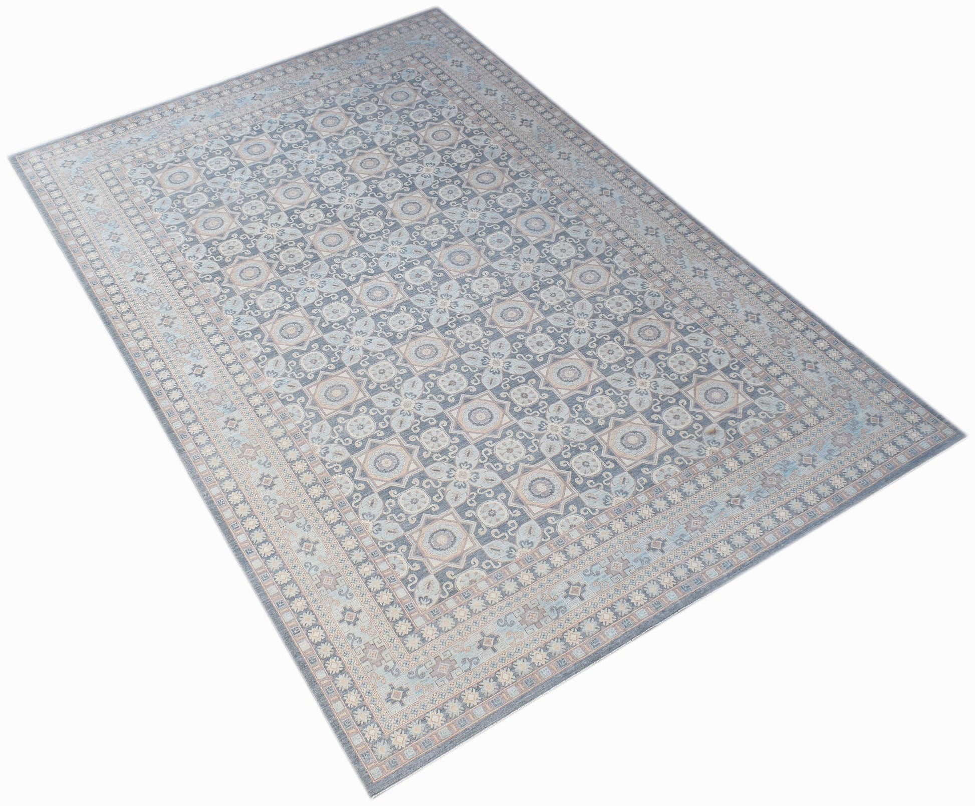 A rectangular Afghan Chobi rug featuring a traditional geometric pattern in muted blue and beige.