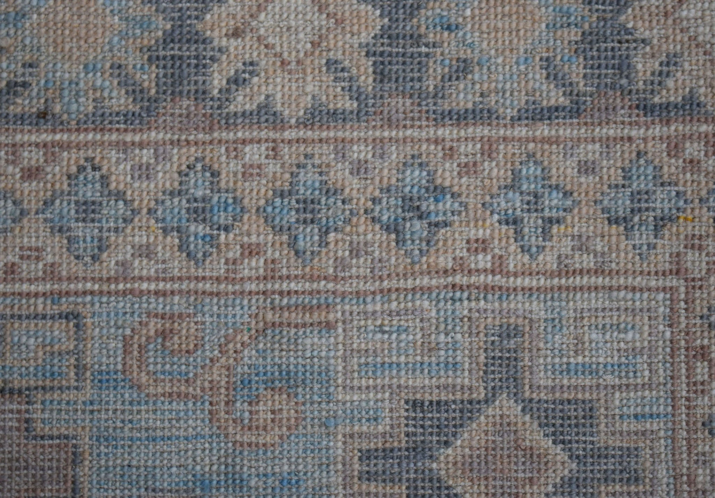 A close-up view of a handwoven Afghan Chobi rug featuring intricate floral and geometric patterns.