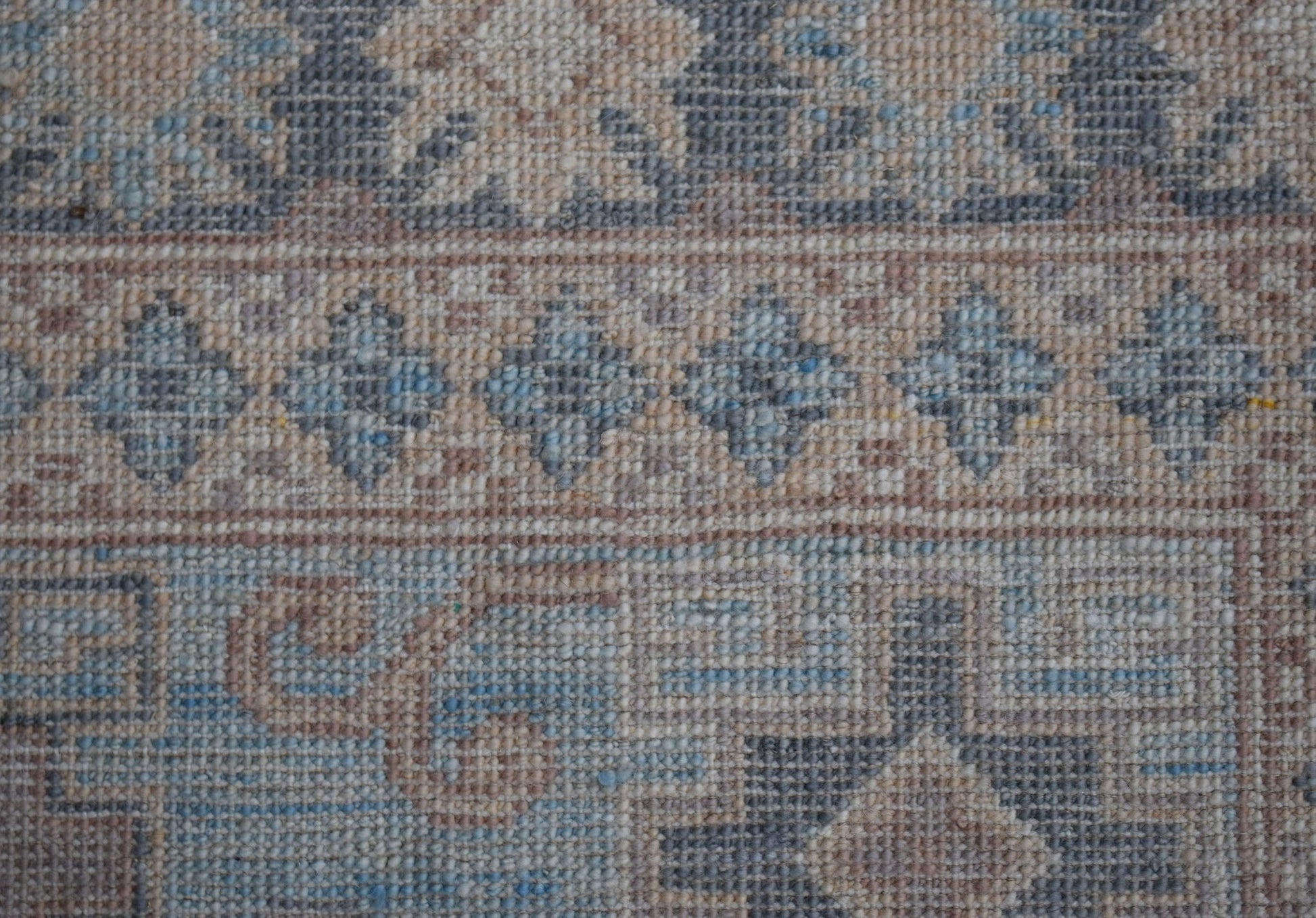 A close-up view of a handwoven Afghan Chobi rug featuring intricate floral and geometric patterns.