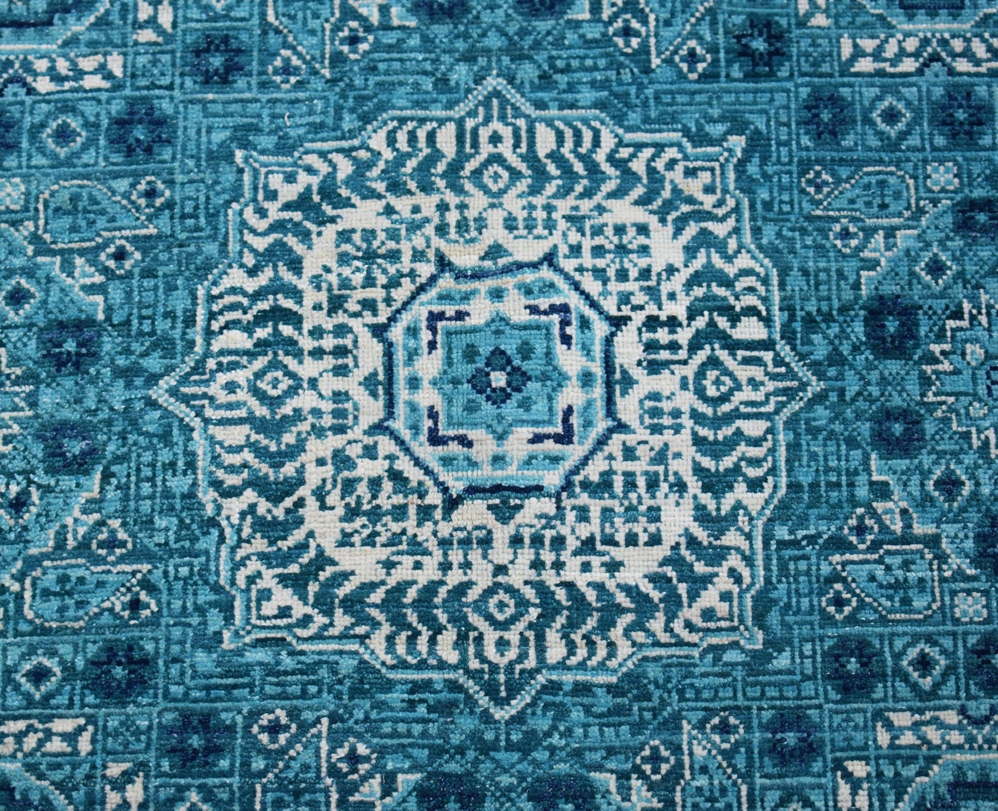 A handmade Afghan Mamluk rug featuring an intricate blue and white geometric medallion pattern.