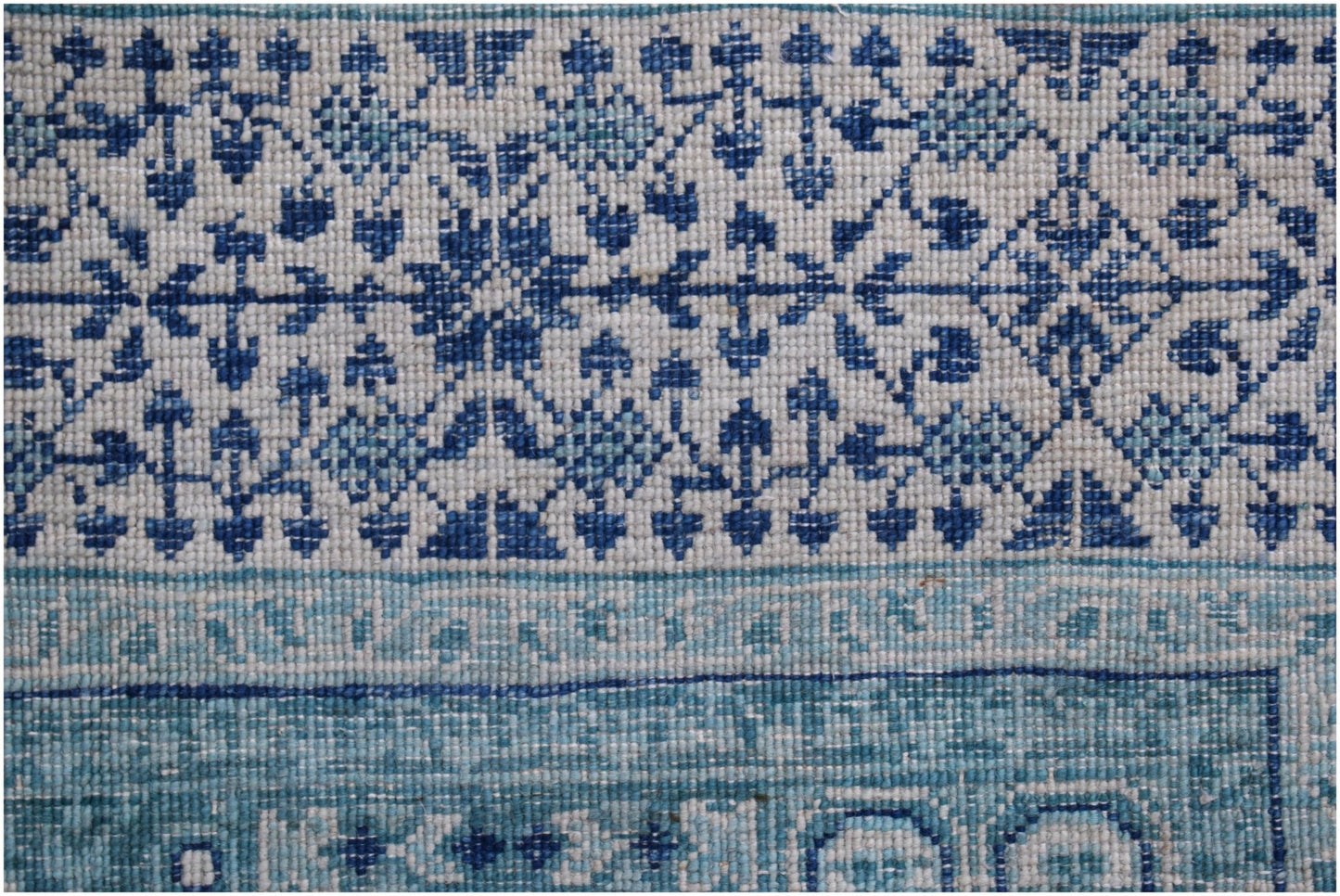 A handwoven Afghan Chobi rug featuring a detailed blue and white Mamluk geometric pattern.