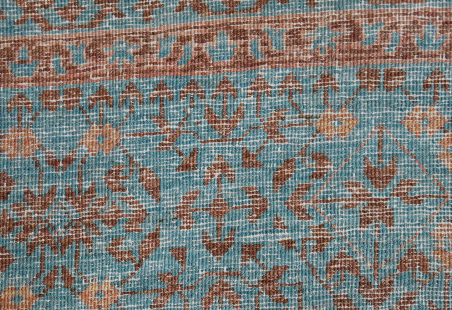 A close-up of a handmade Afghan Chobi rug featuring a detailed Mamluk pattern in blue and brown.