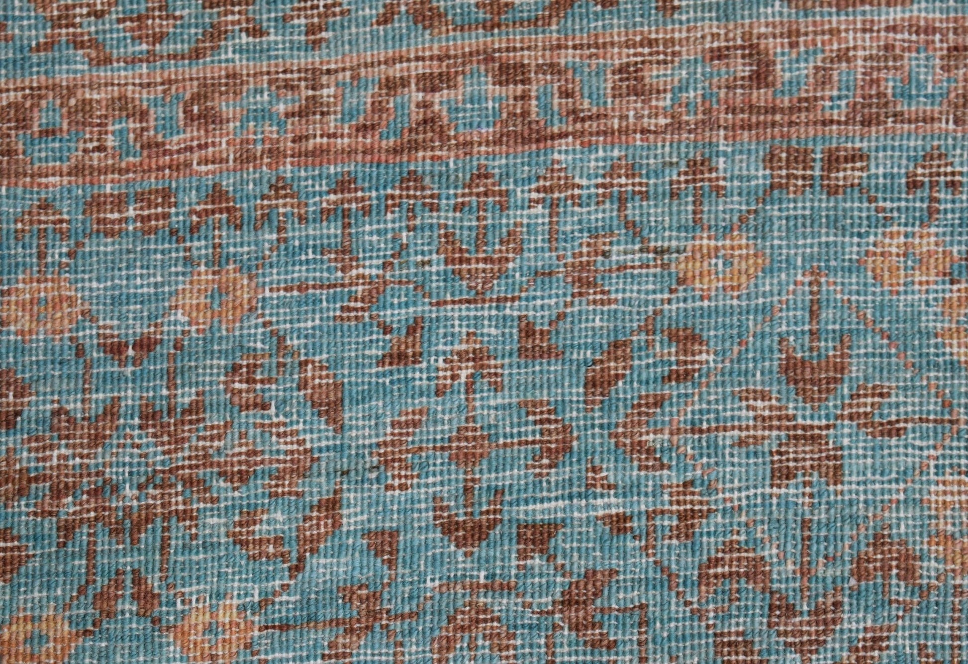 A close-up of a handmade Afghan Chobi rug featuring a detailed Mamluk pattern in blue and brown.