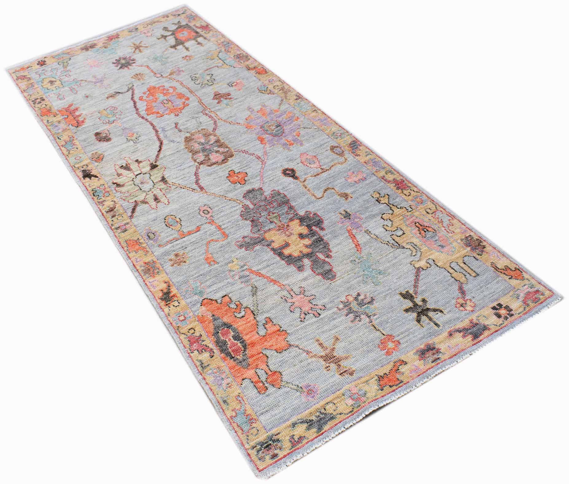 A handwoven transitional Oushak runner featuring a floral pattern in muted tones on a grey field.