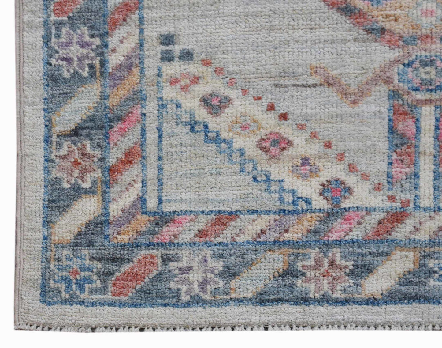 A handwoven transitional Oushak runner featuring a floral pattern in soft, muted colors.
