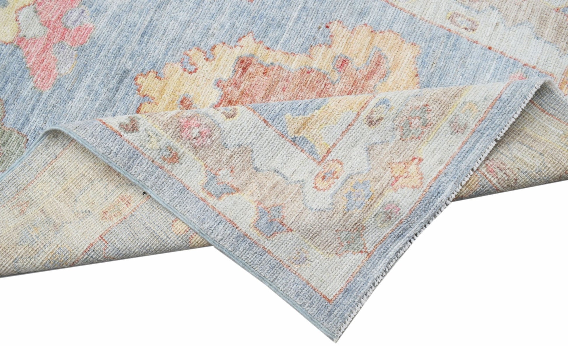 A handwoven transitional Oushak runner featuring a floral pattern in soft blue and muted tones.