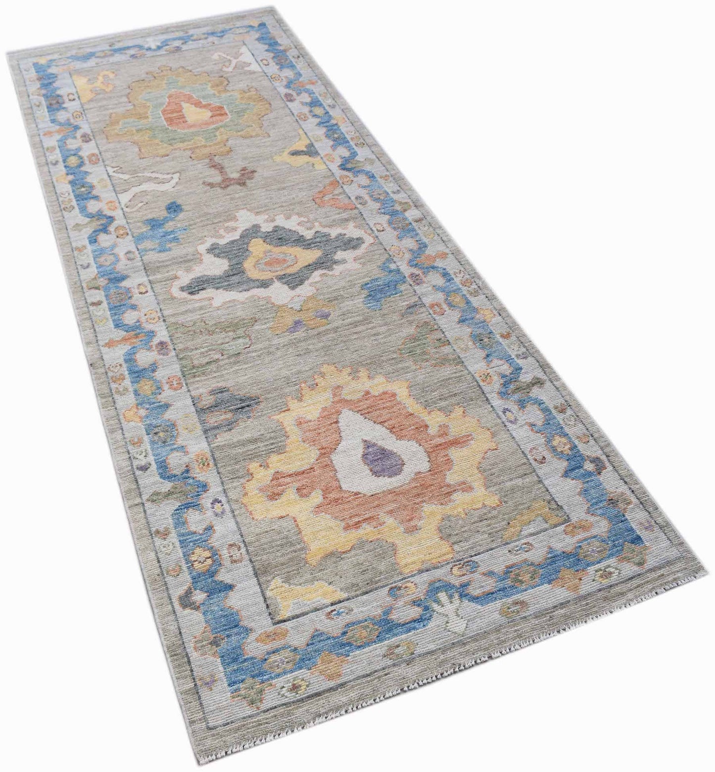 A handwoven transitional Oushak runner rug featuring a floral pattern in blue, yellow, and orange.