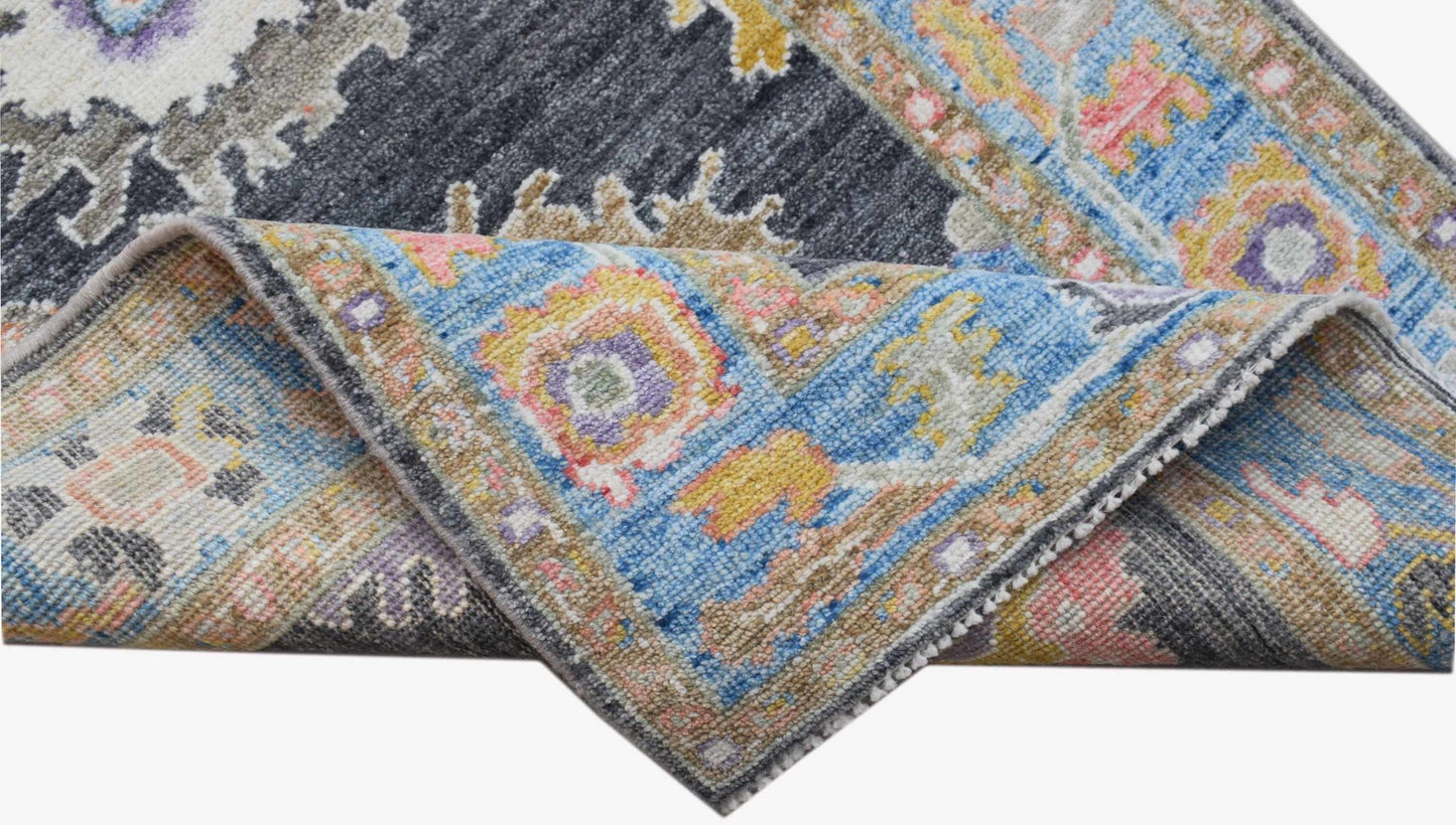 A handwoven transitional Oushak runner featuring a floral pattern in blue, grey, and yellow tones.