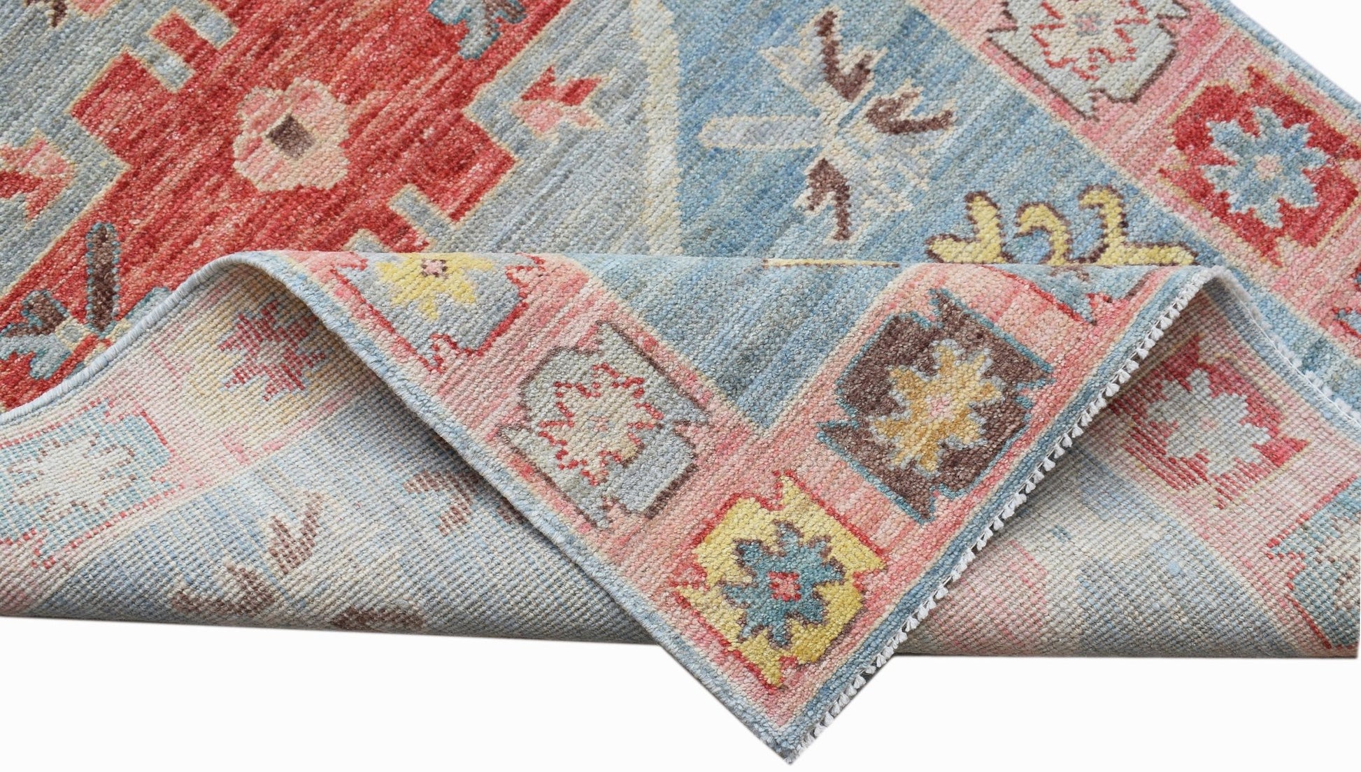 A handwoven transitional Oushak runner featuring a floral pattern in blue, red, and pink tones.