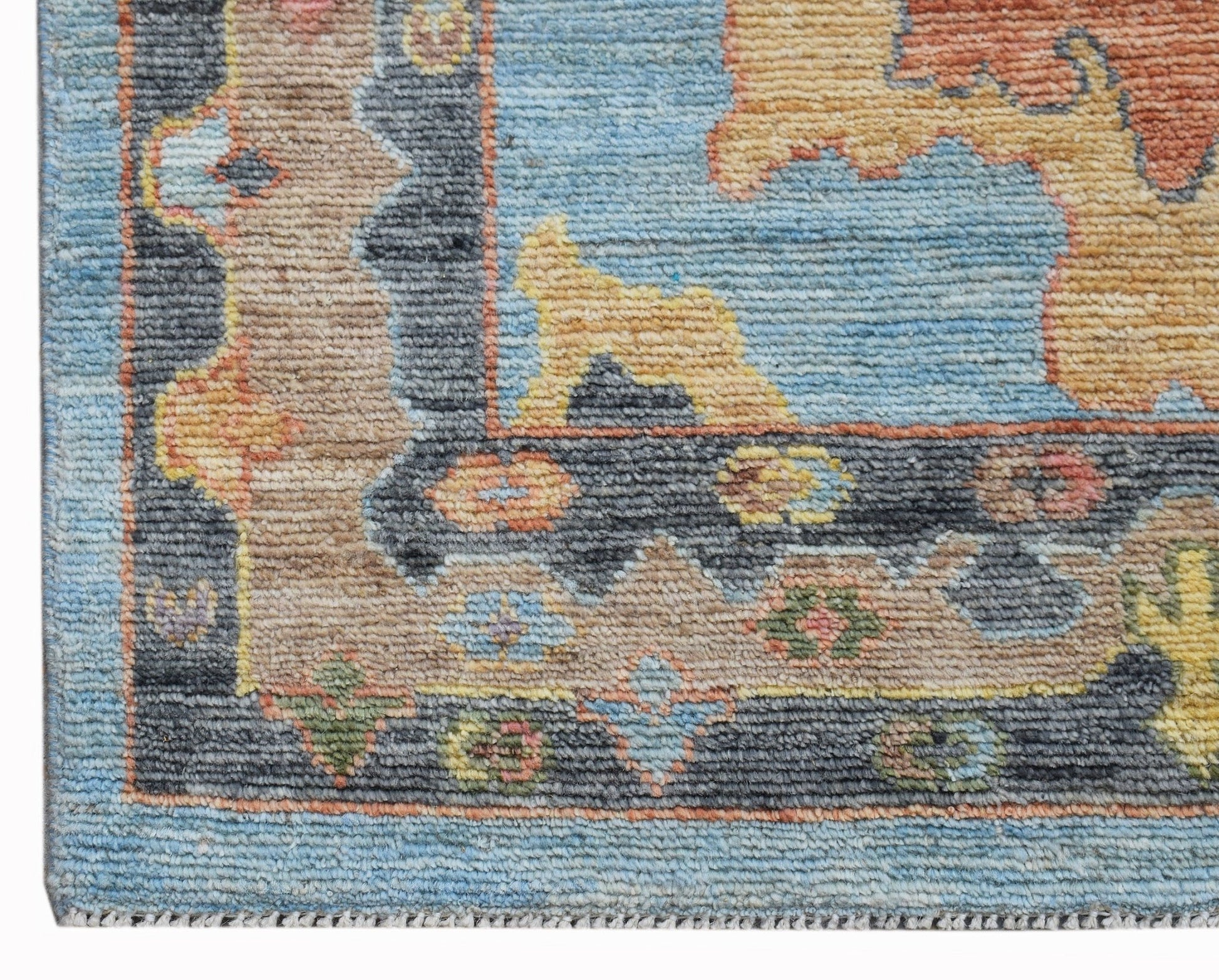 A transitional Oushak runner featuring a floral pattern in blue, tan, and orange wool.
