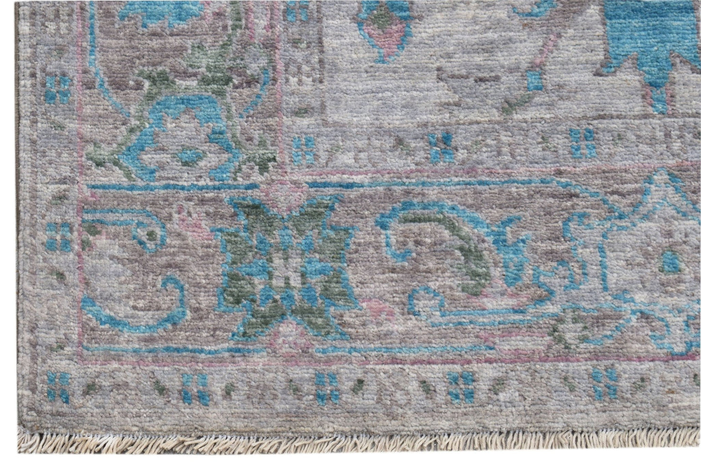 A handwoven transitional Oushak runner featuring a floral pattern in blue, grey, and pink tones.