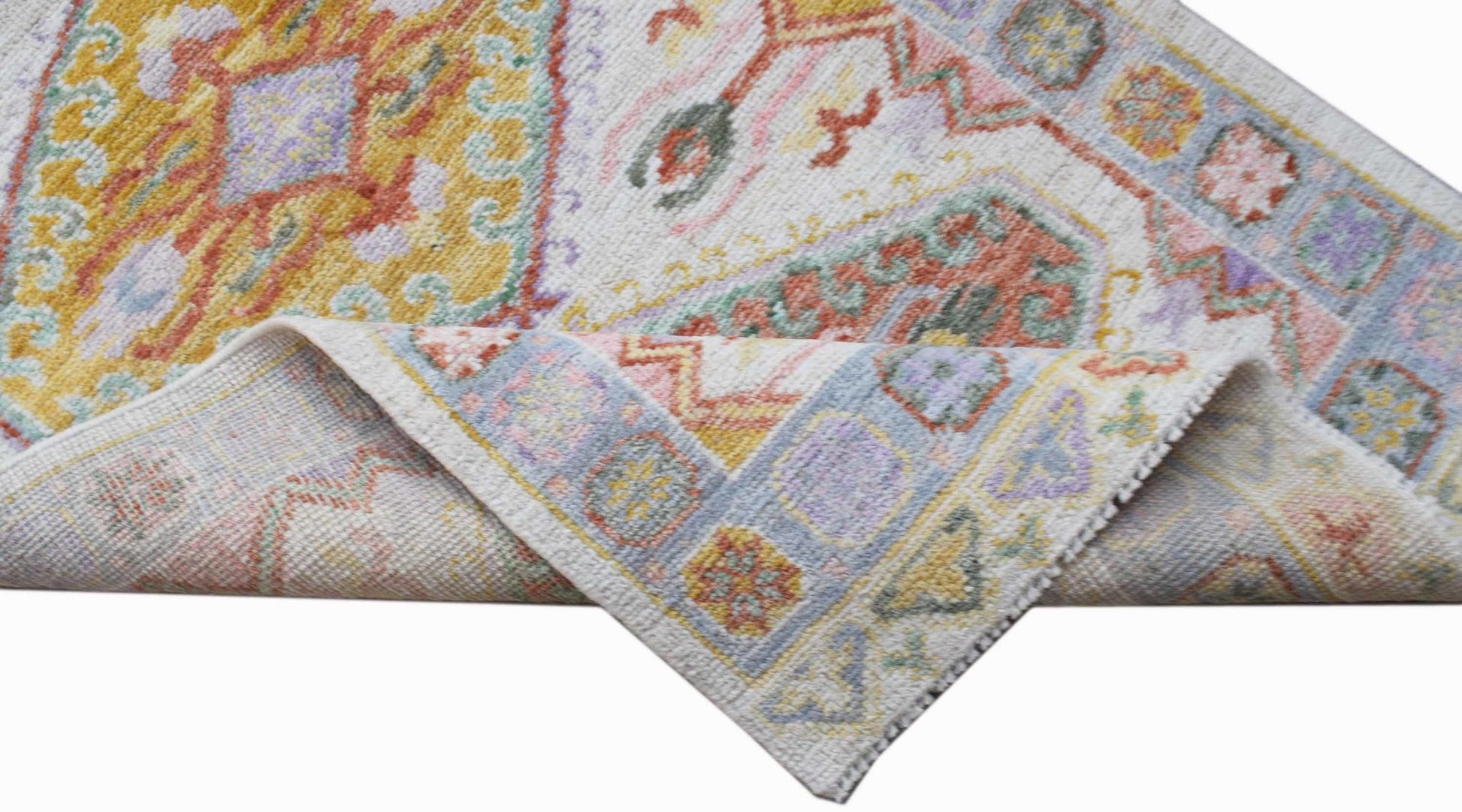 A handwoven transitional Oushak runner featuring a floral pattern in soft, multi-colored tones.