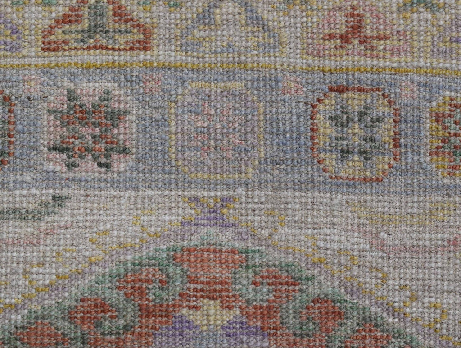 A handwoven wool runner featuring a transitional Oushak pattern in soft, muted colors.