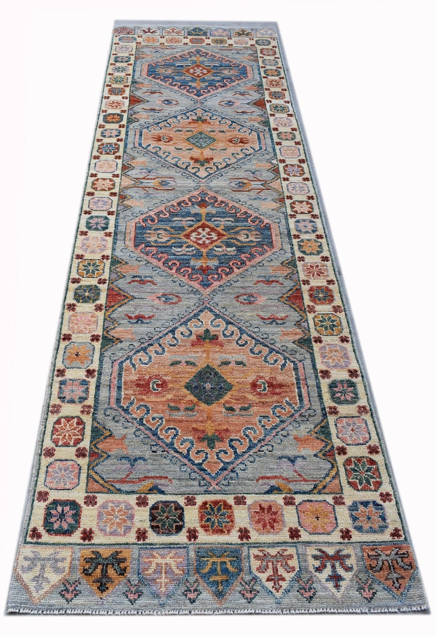 A handwoven transitional Oushak runner featuring geometric medallions in blue and orange tones.