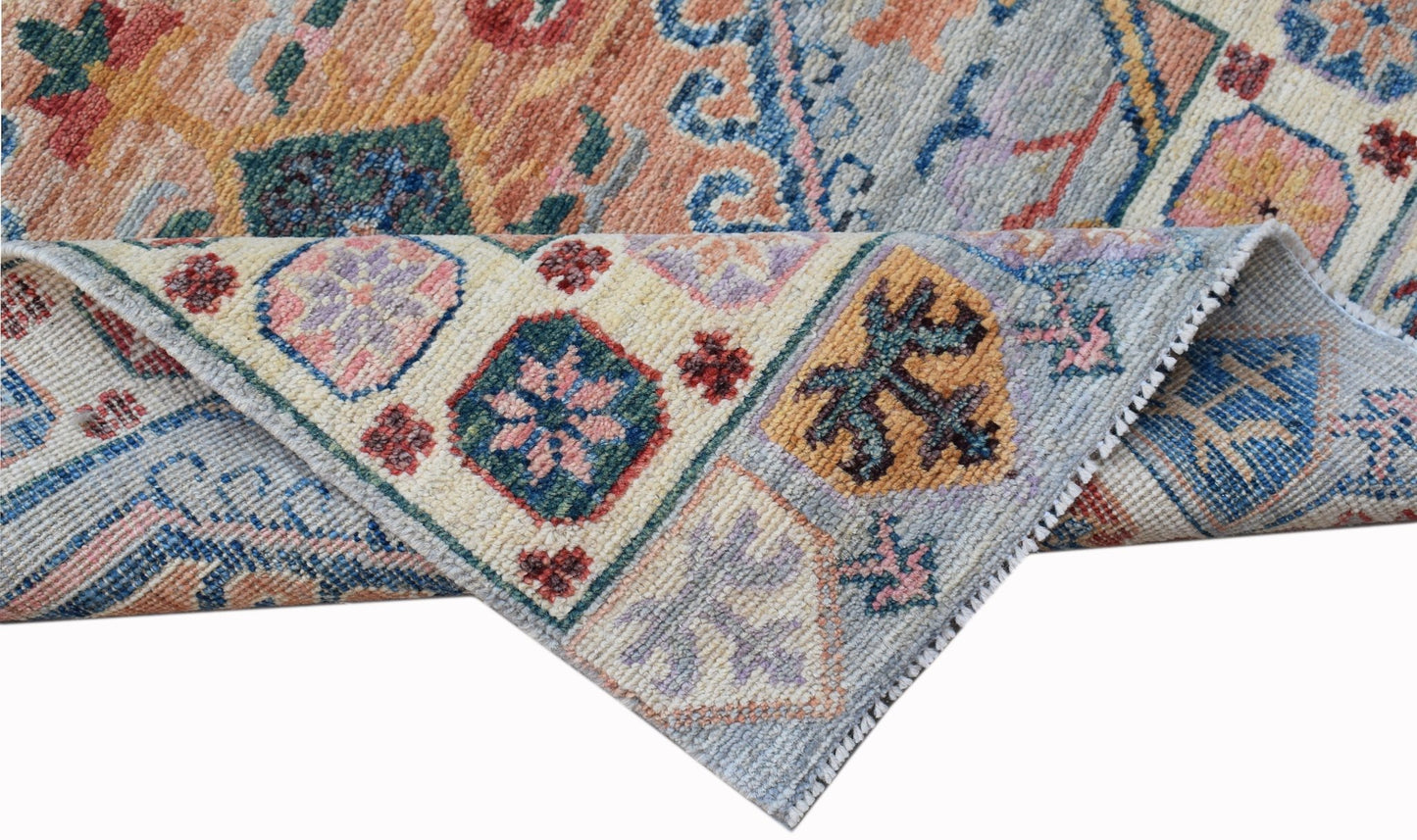 A handwoven transitional Oushak runner featuring a floral pattern in soft, multi-colored wool.
