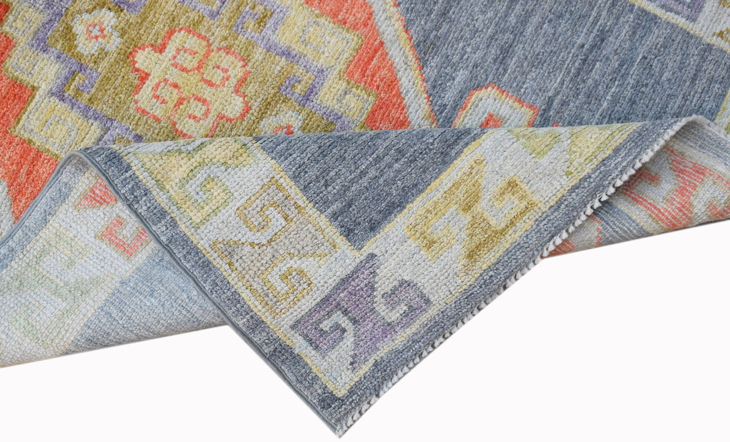 A handwoven transitional Oushak runner featuring a geometric pattern in blue, orange, and yellow.