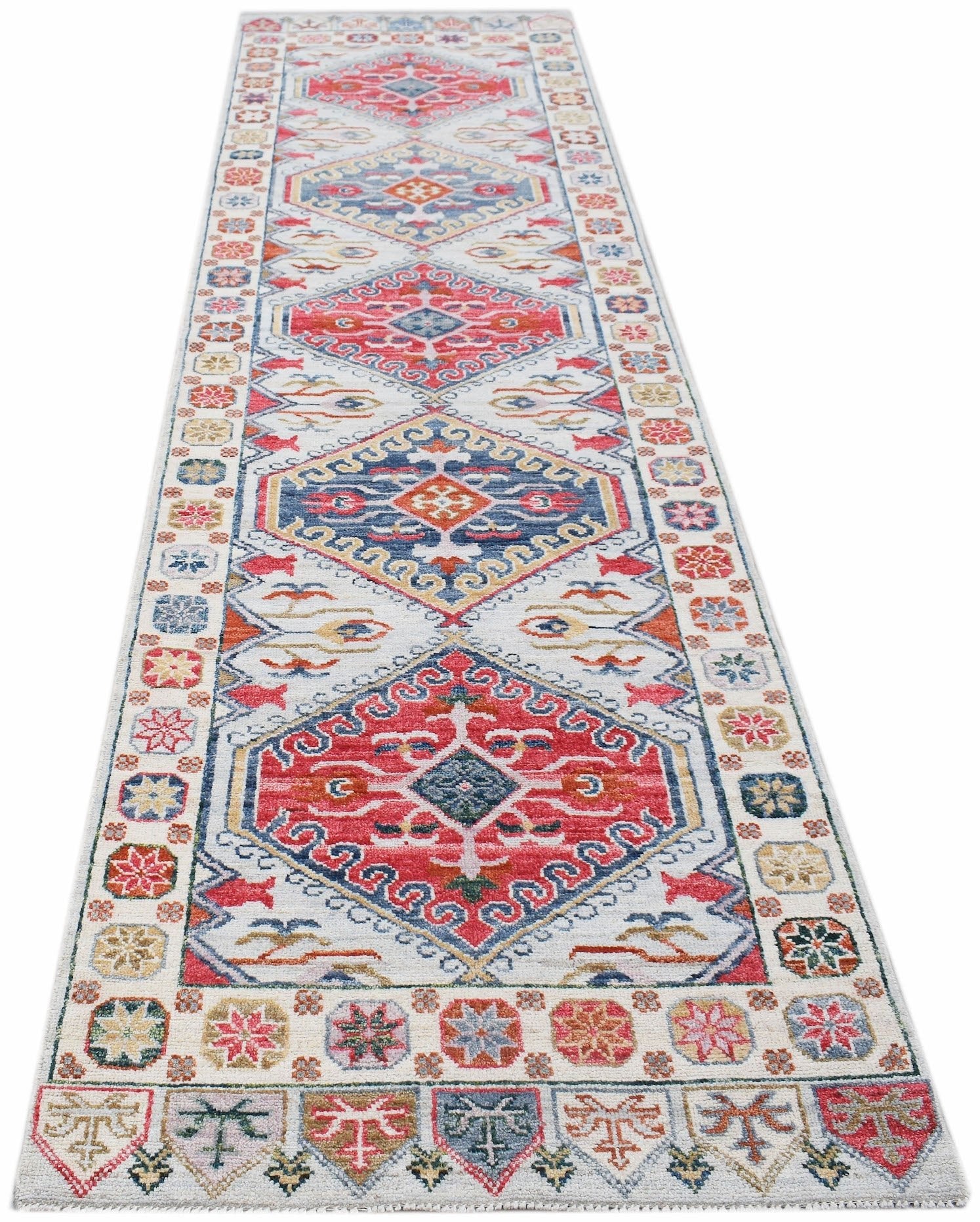 A handwoven transitional Oushak runner rug featuring a colorful geometric pattern on a light base.