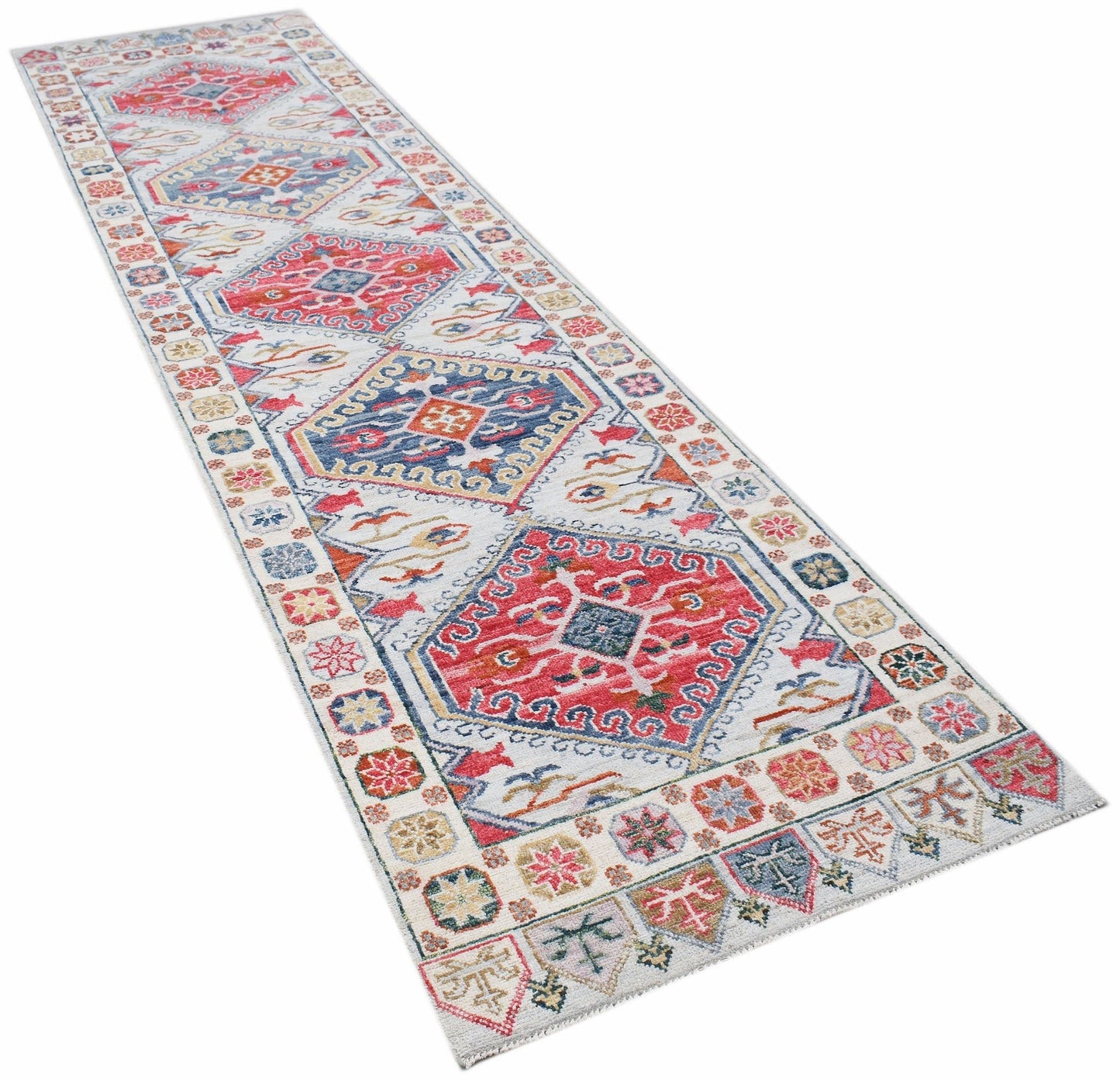 A handwoven wool runner rug featuring a transitional Oushak pattern in red, blue, and cream tones.