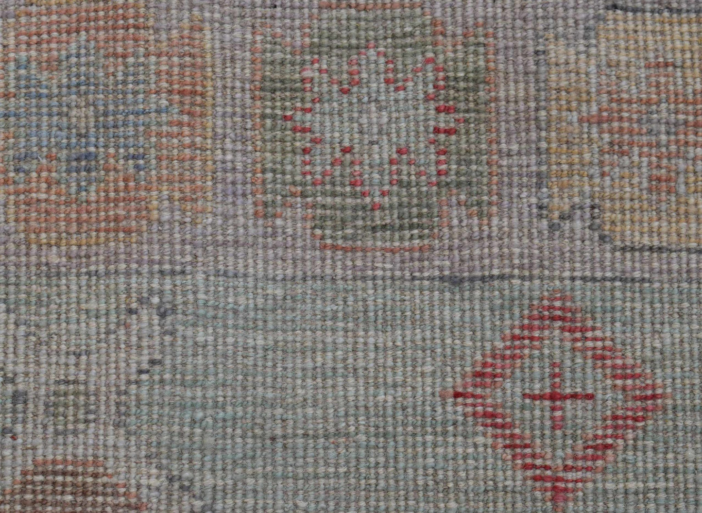 A handwoven wool runner featuring a transitional Oushak pattern in muted tones.