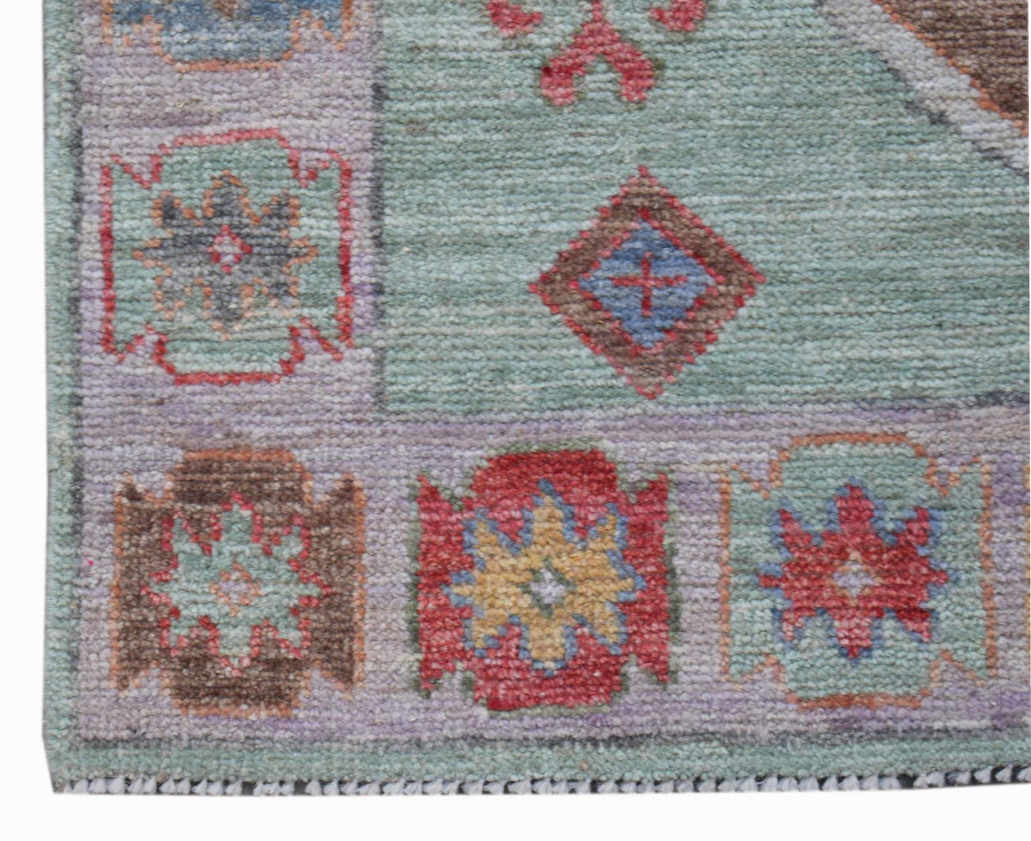 A handwoven wool runner featuring a transitional Oushak pattern in soft, multi-colored tones.
