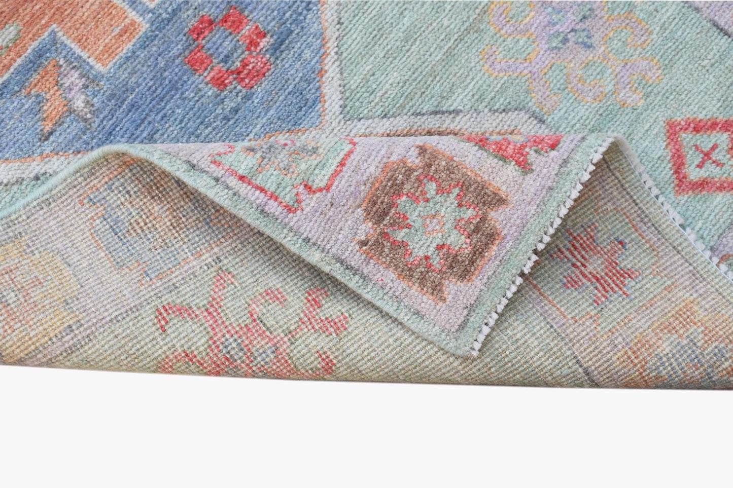 A handwoven transitional Oushak runner featuring a floral pattern in soft blue and pastel tones.