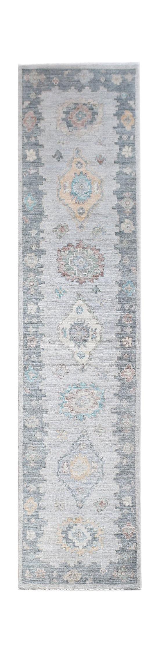 A handwoven transitional Oushak runner rug featuring a light blue field with floral motifs.