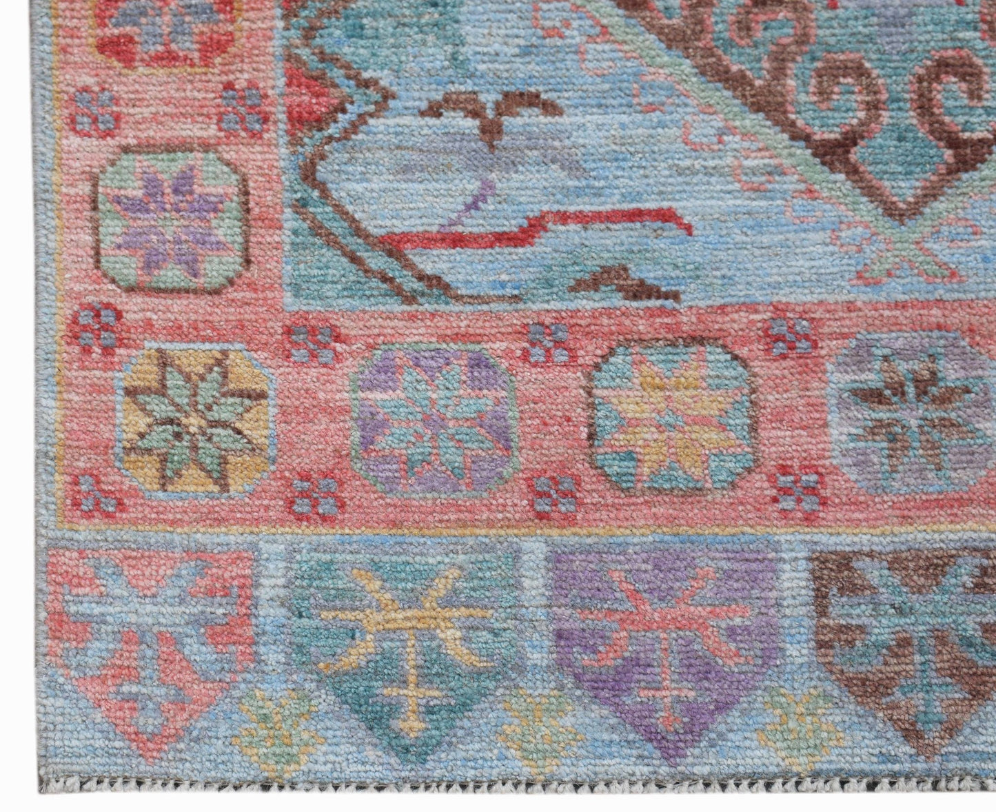 A handwoven wool runner featuring a transitional Oushak pattern in soft, multi-colored tones.
