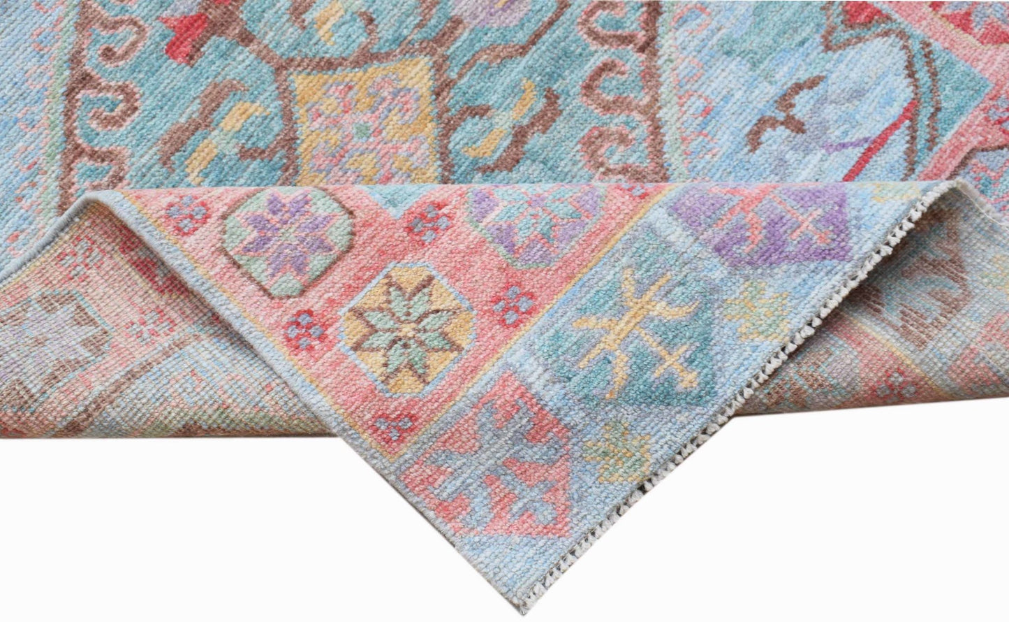 A handwoven transitional Oushak runner featuring a floral pattern in soft pastel colors.