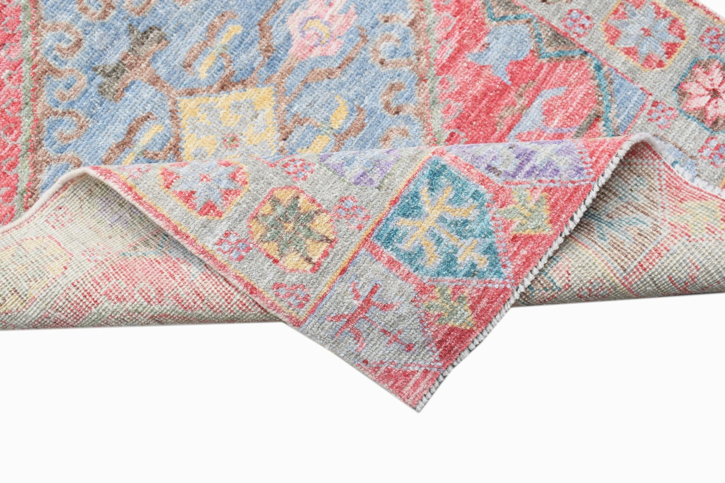 A handwoven transitional Oushak runner featuring a floral pattern in blue, red, and yellow tones.