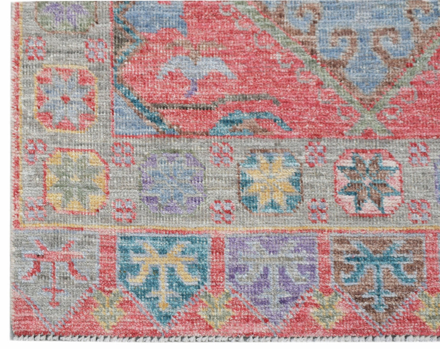 A handwoven transitional Oushak runner featuring a geometric floral pattern in vibrant colors.
