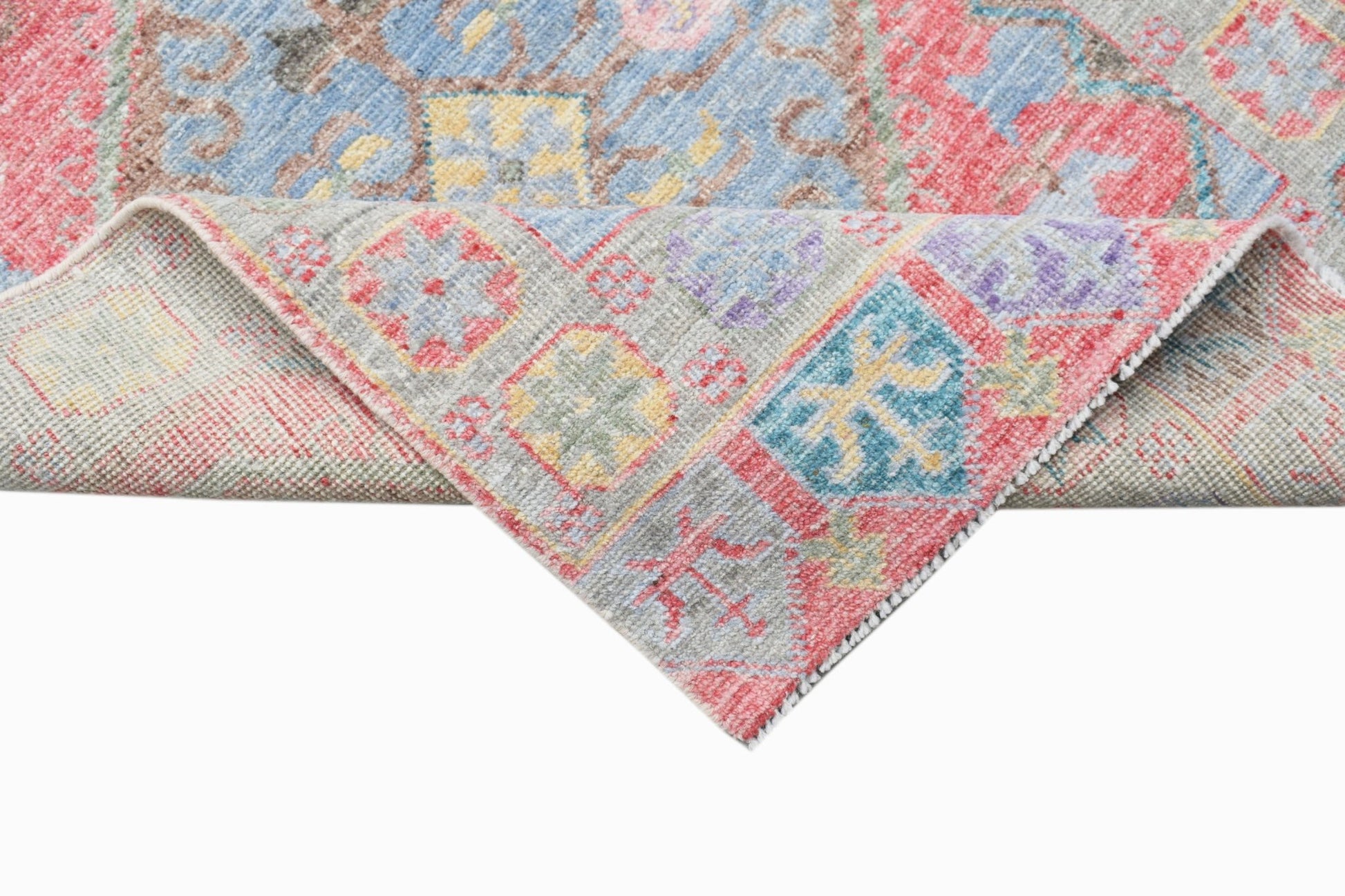 A handwoven wool runner featuring a transitional Oushak pattern in vibrant red and blue tones.